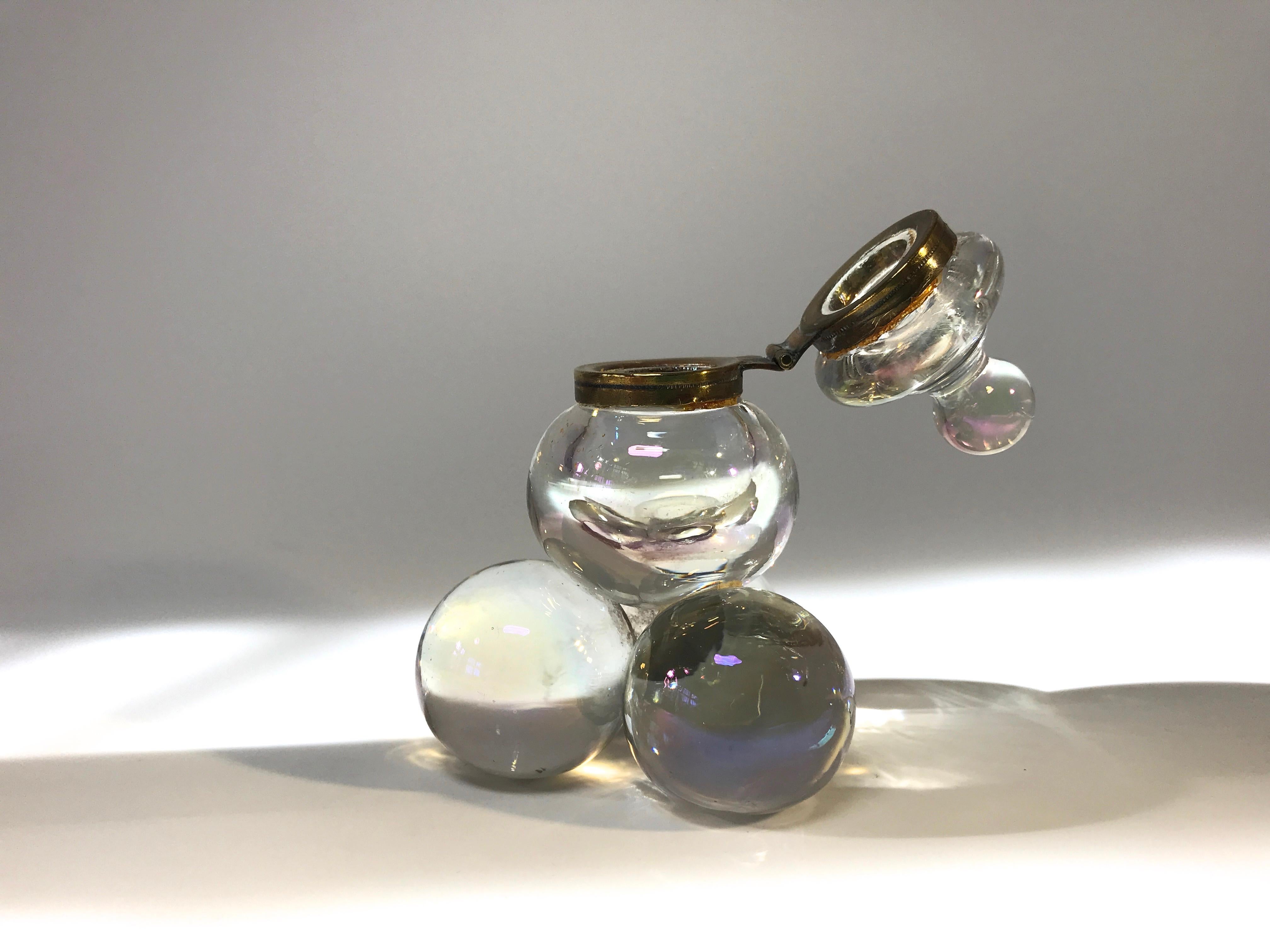 A delightful iridescent glass Soap Bubble lidded glass inkwell from the late 1800s with a brass hinged collar.
This is quite possibly made by Harrach, Bohemia
Delicate and charming, this piece is a reminder of a more genteel time
Although from