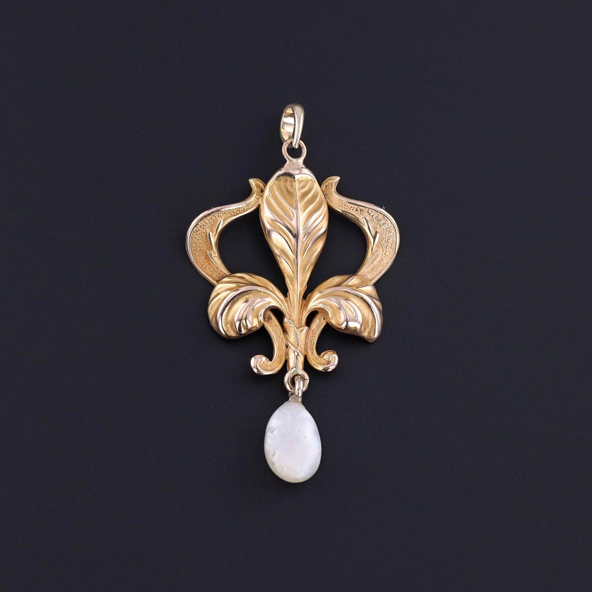 Ce pendentif de style Art Nouveau (vers 1890) représente un iris doré surmontant une perle d'eau douce.

Le pendentif en or 10k mesure 1,6 pouces du haut de la caution au bas par 0,9 pouces de large, et il est en excellent état.

La teneur en métaux