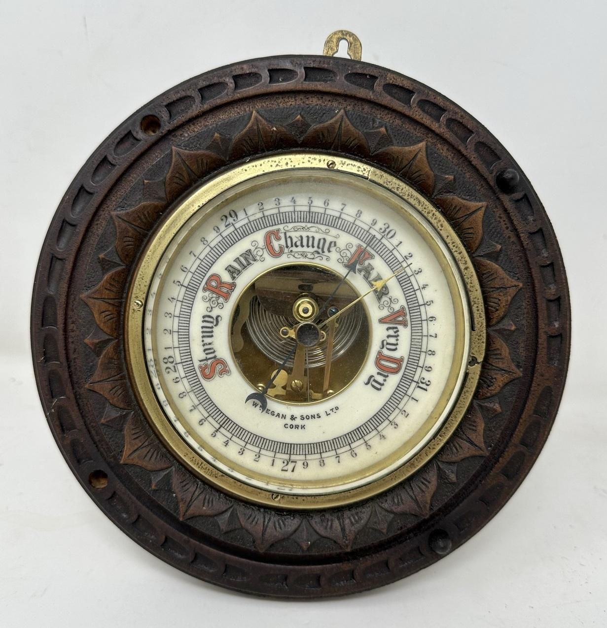 A Wonderful Hand Carved Irish Oak Aneroid Wall Barometer of compact size, encased within a circular oak case with attractive leaf carvings. Retailed by William Egan & Sons. Patrick Street, Cork, Ireland. Mid to late Nineteenth Century. 

Brass Bezel