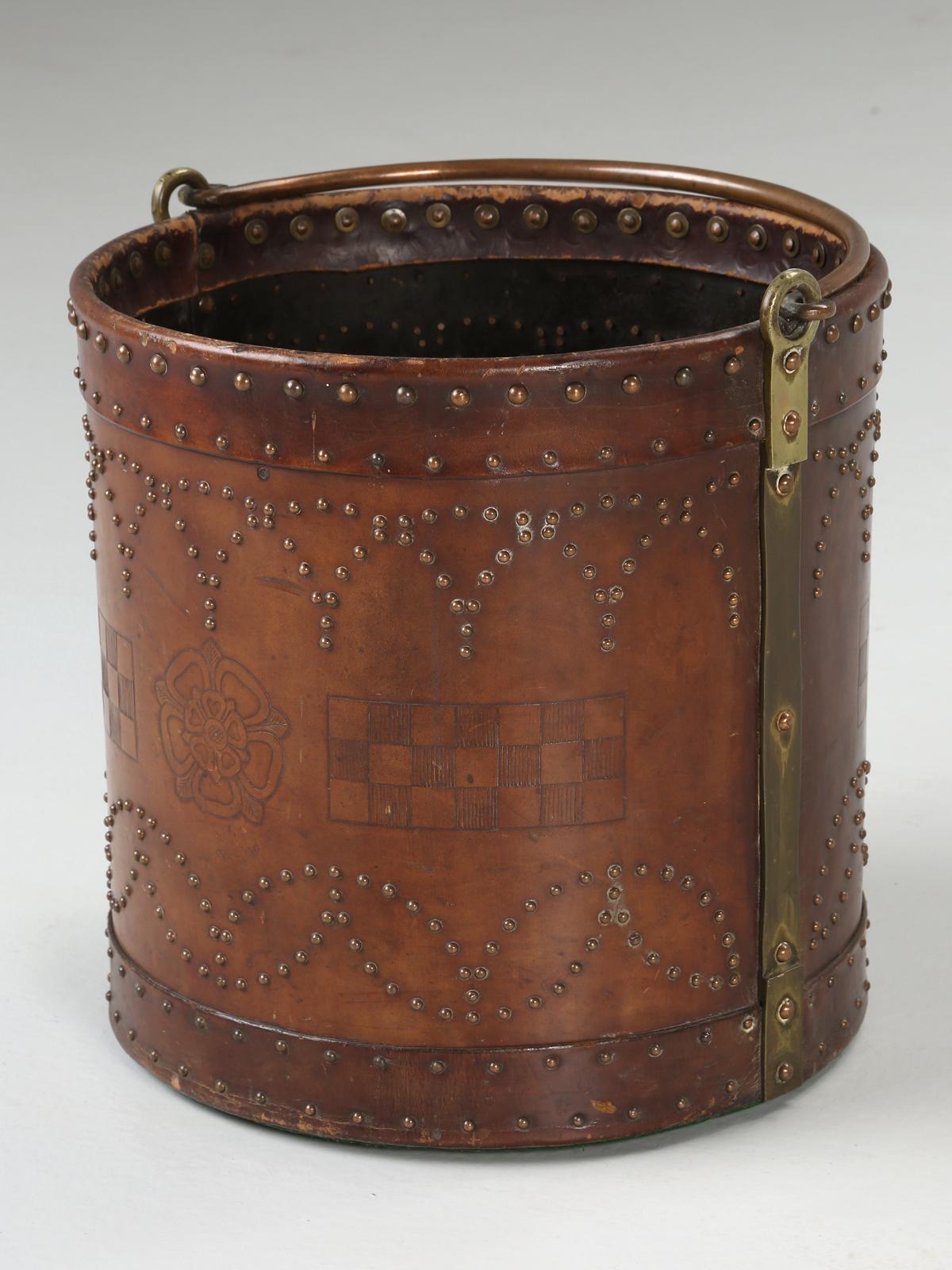 An exceptional antique Irish coal bucket from the Arts & Craft period. The leather has several tooled designs and are highlighted by the pattern of the nail heads. Would make an ideal log holder for someone’s fireplace. This is probably one of the