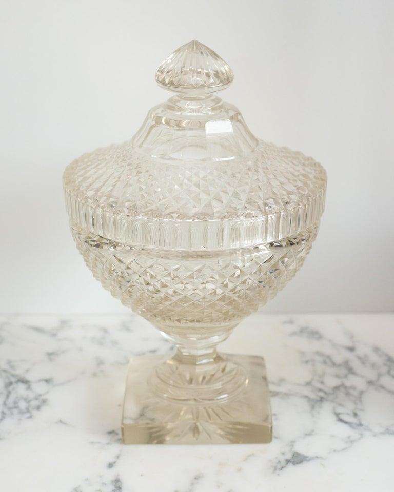 Este cuenco decorativo de cristal tallado irlandés antiguo con tapa a juego es un accesorio clásico fácil de colocar en cualquier hogar. Perfecto para servir o decorar, se puede rellenar de fruta o caramelos.