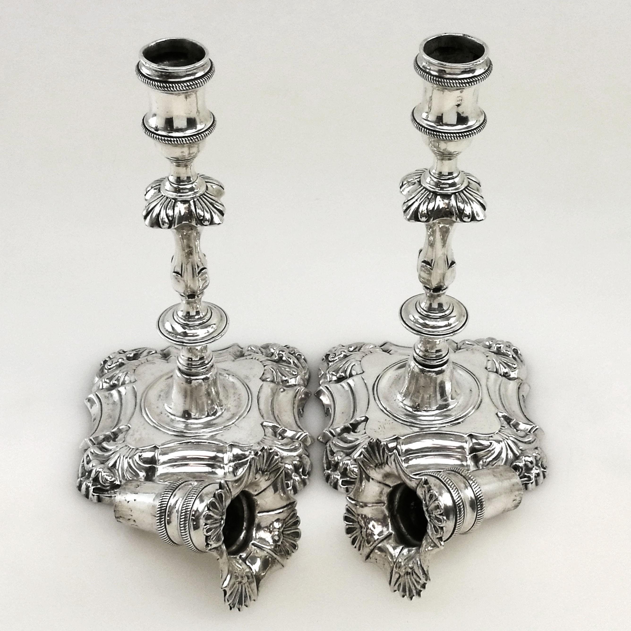A gorgeous pair of Antique Irish George II Georgian cast solid silver candlesticks. These silver candlesticks stand on shaped square bases with tall elegant knopped columns. The candlesticks each have a tall removable fitted sconce. These