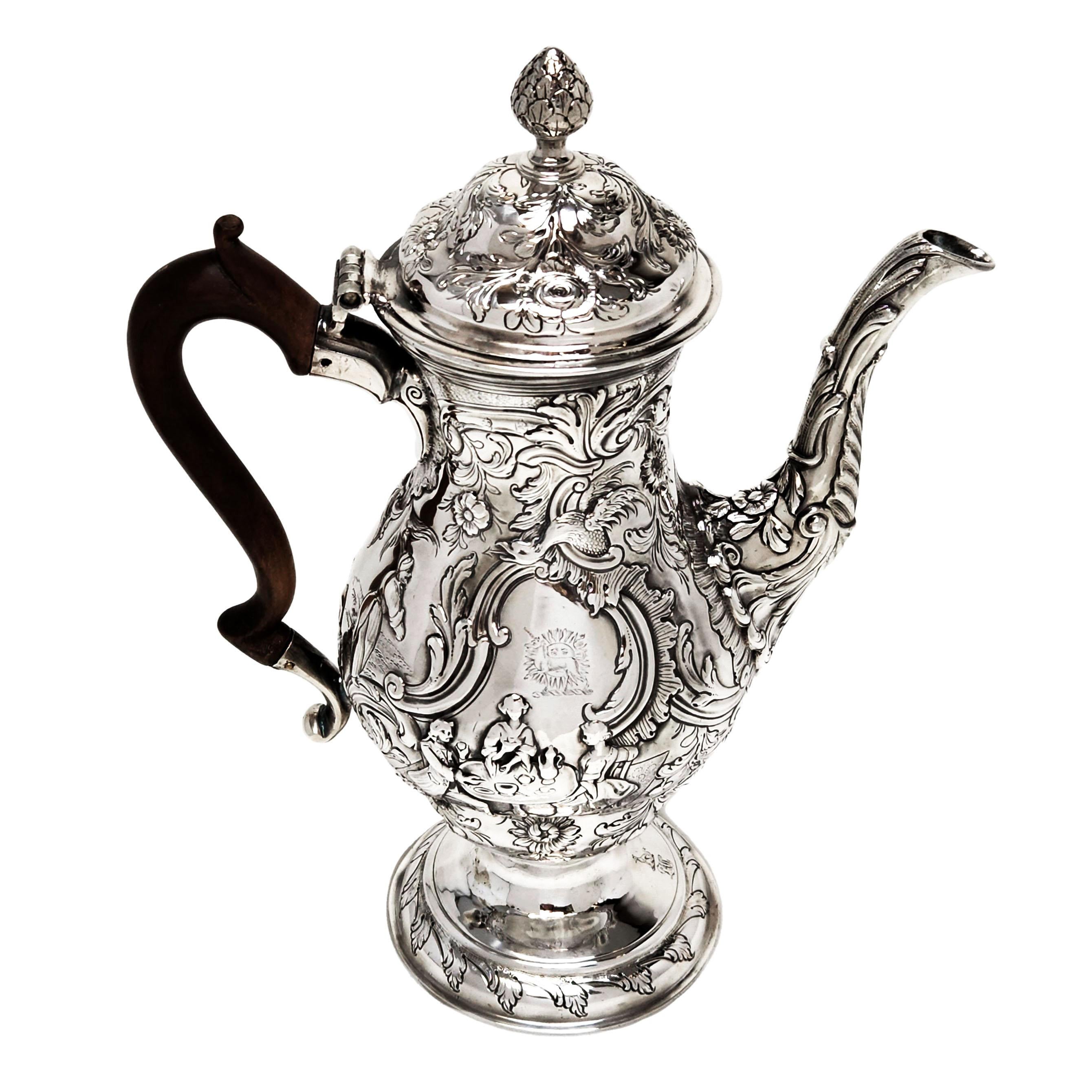 A magnificent antique George III Irish silver coffee pot. This sterling silver coffee pot has a classic baluster shape and is embellished with ornate chased patterning surrounding two shaped cartouches. The chased images show figures seated at a