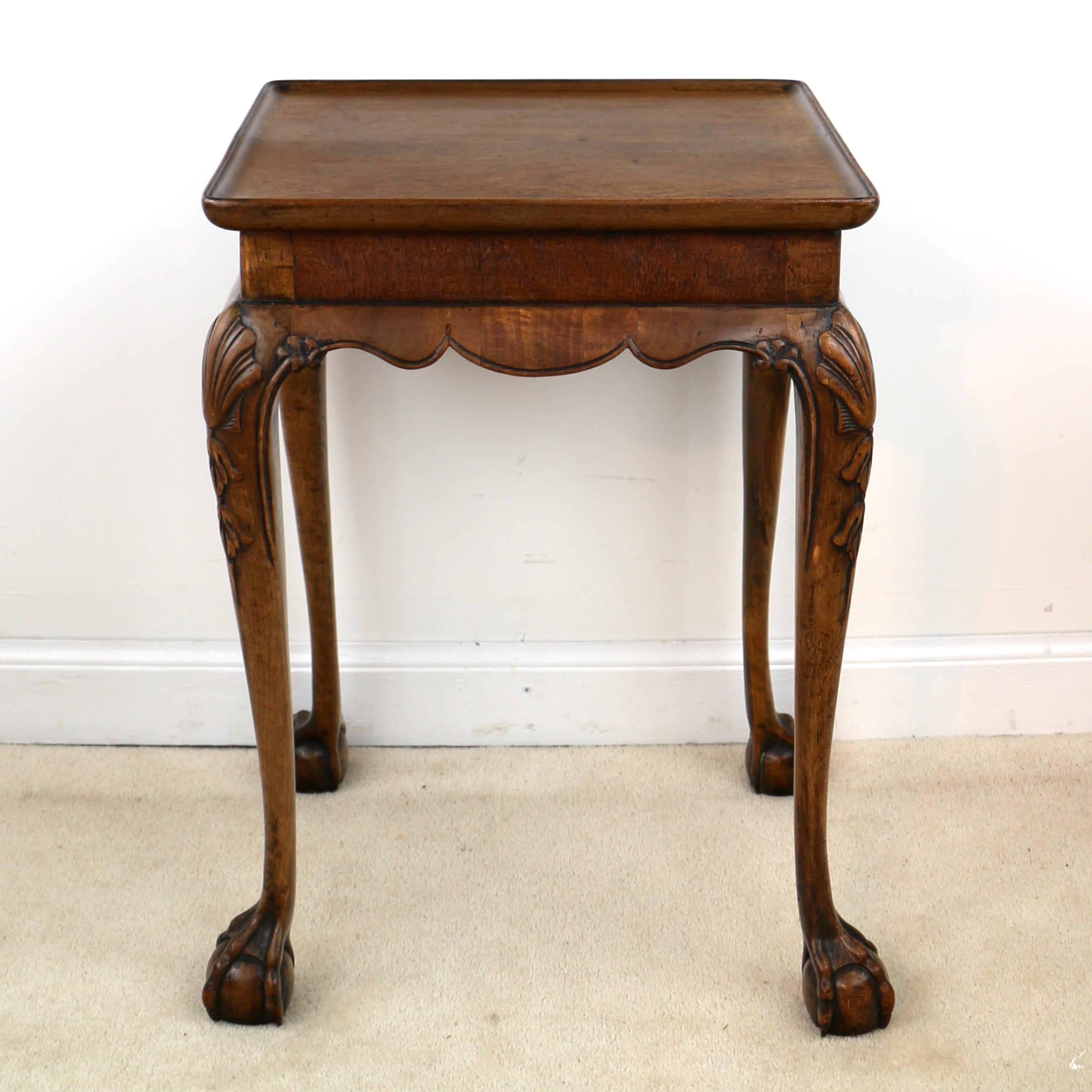 A rare Georgian Irish Chippendale small silver table or kettlestand in solid walnut, the rectangular top with a carved dished edge above a straight sided frieze and out-curved carved shaped apron and standing on elegant shell carved legs with webbed