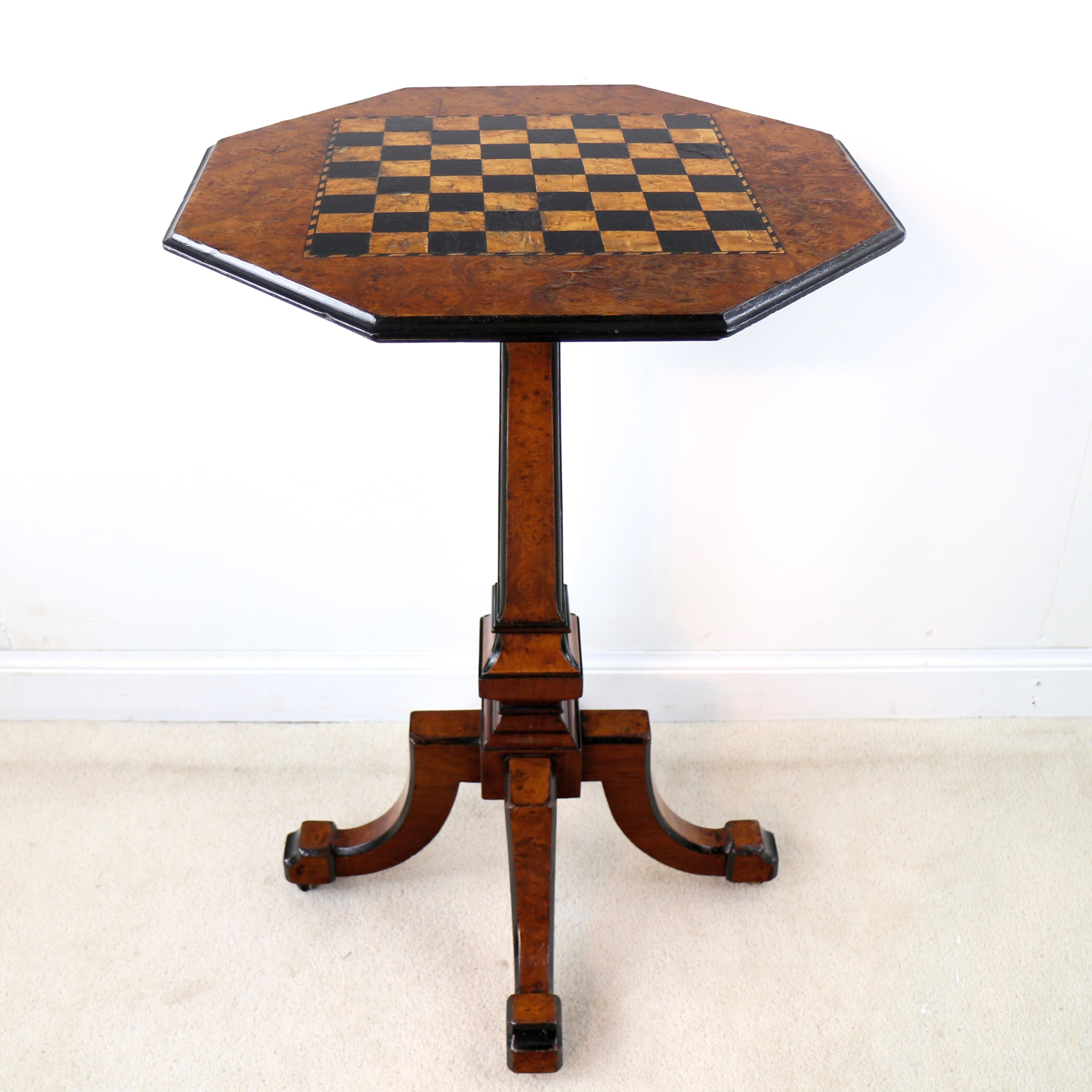 A charming and rare Victorian Irish Killarney yew and ebonised games table, the octagonal shaped top inlaid with birds-eye maple and ebonised squares edged with an arbutus and ebony rope-twist border and ebonised moulded edge, supported on a square