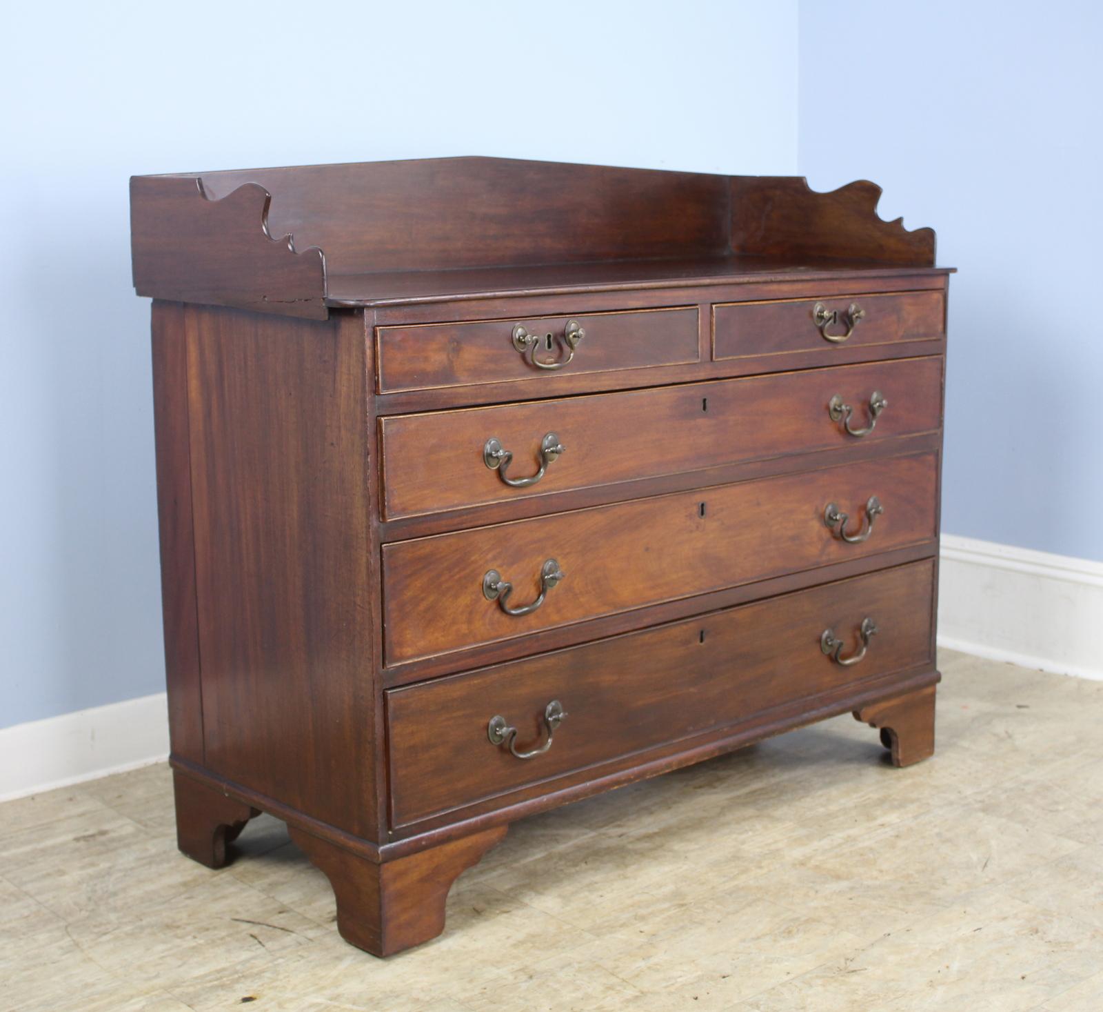 A charming Irish chest with whimsical galleried back. Originally intended to store silver and linens, this piece would be good in the bedroom or anywhere attractive storage is needed. Original hardware. Measurement below is for the total height. The