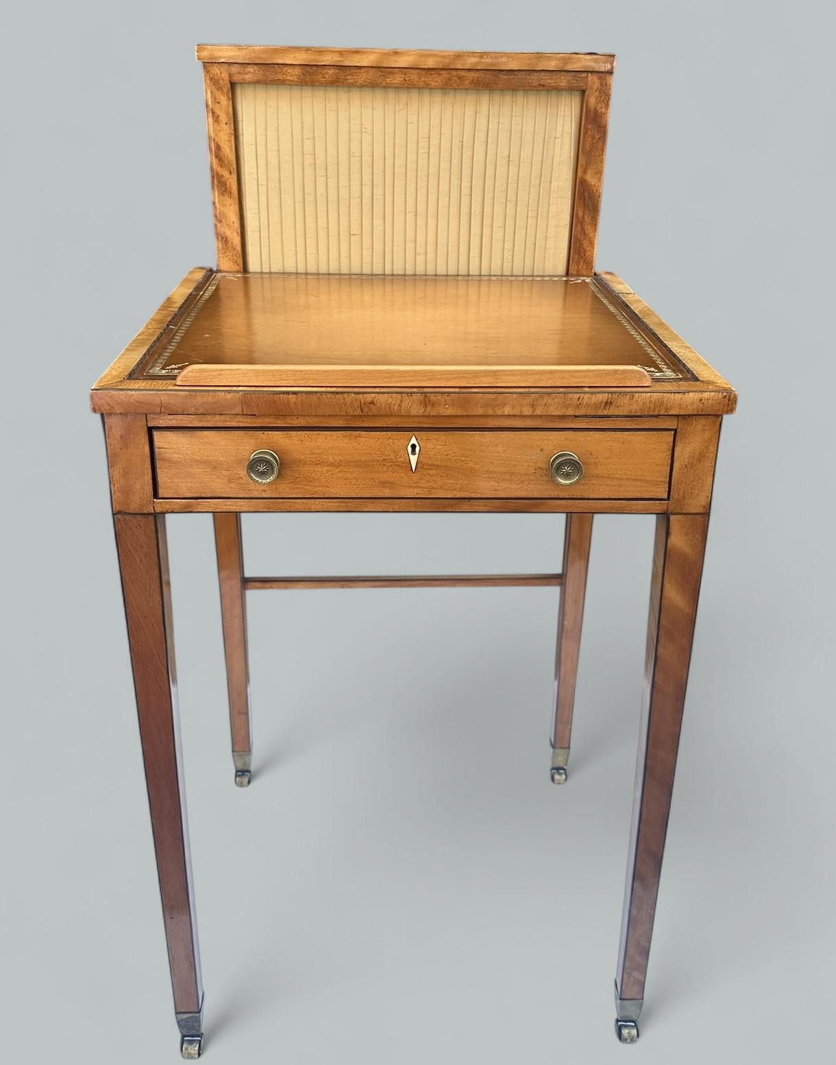 A Very Imposing example of an Irish well figured Satinwood rectangular Writing or Occasional Table complete with gilt tooled leather writing surface with lift up mechanism which could also be as a Lectern, an adjustable heat fabric silk lined shield