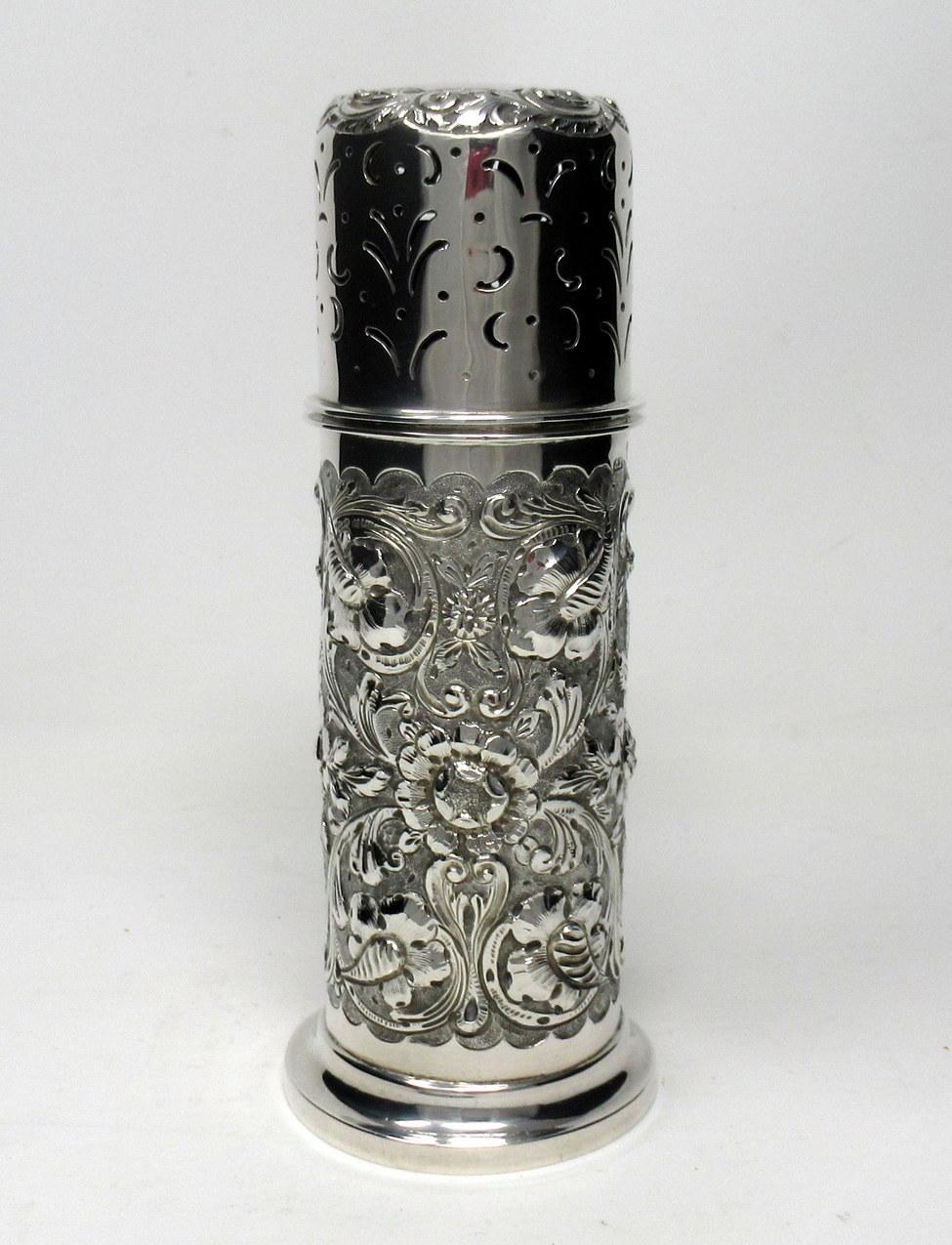 Stunning Irish heavy gauge silver two part table sugar caster Muffineer of cylindrical or lighthouse form and of outstanding quality ending on a circular spreading base.

The entire embossed with flowers leaves and scrolls, with elements of Art