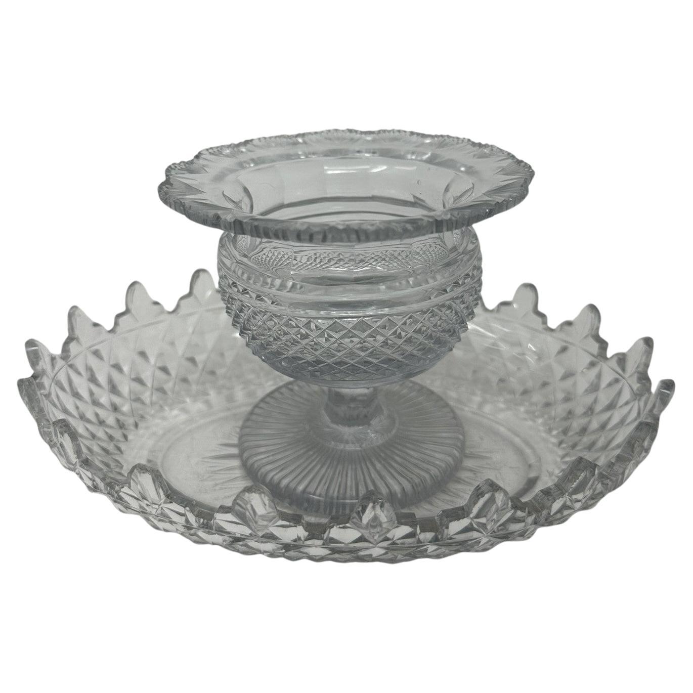 Impresionante cuenco de cristal irlandés con pedestal volteado, de contorno circular y proporciones compactas, junto con un plato hondo asociado con decoración similar. Ambos fabricados por la Old Waterford Glass Company, en el condado irlandés de