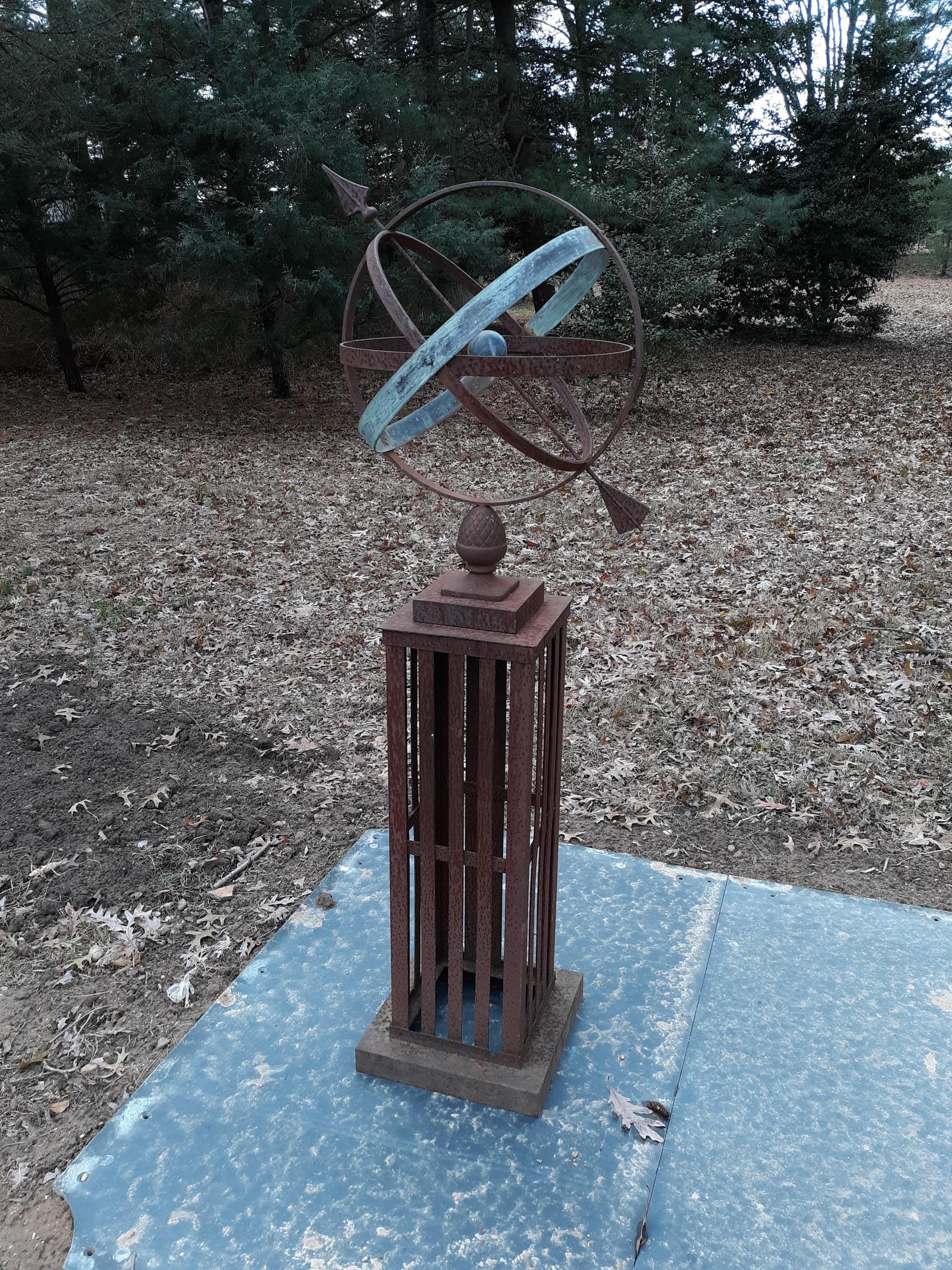 Iron and bronze garden amillary from the early 20th century with original oxidized surface. The Armillary sits on the original square base, in two parts.