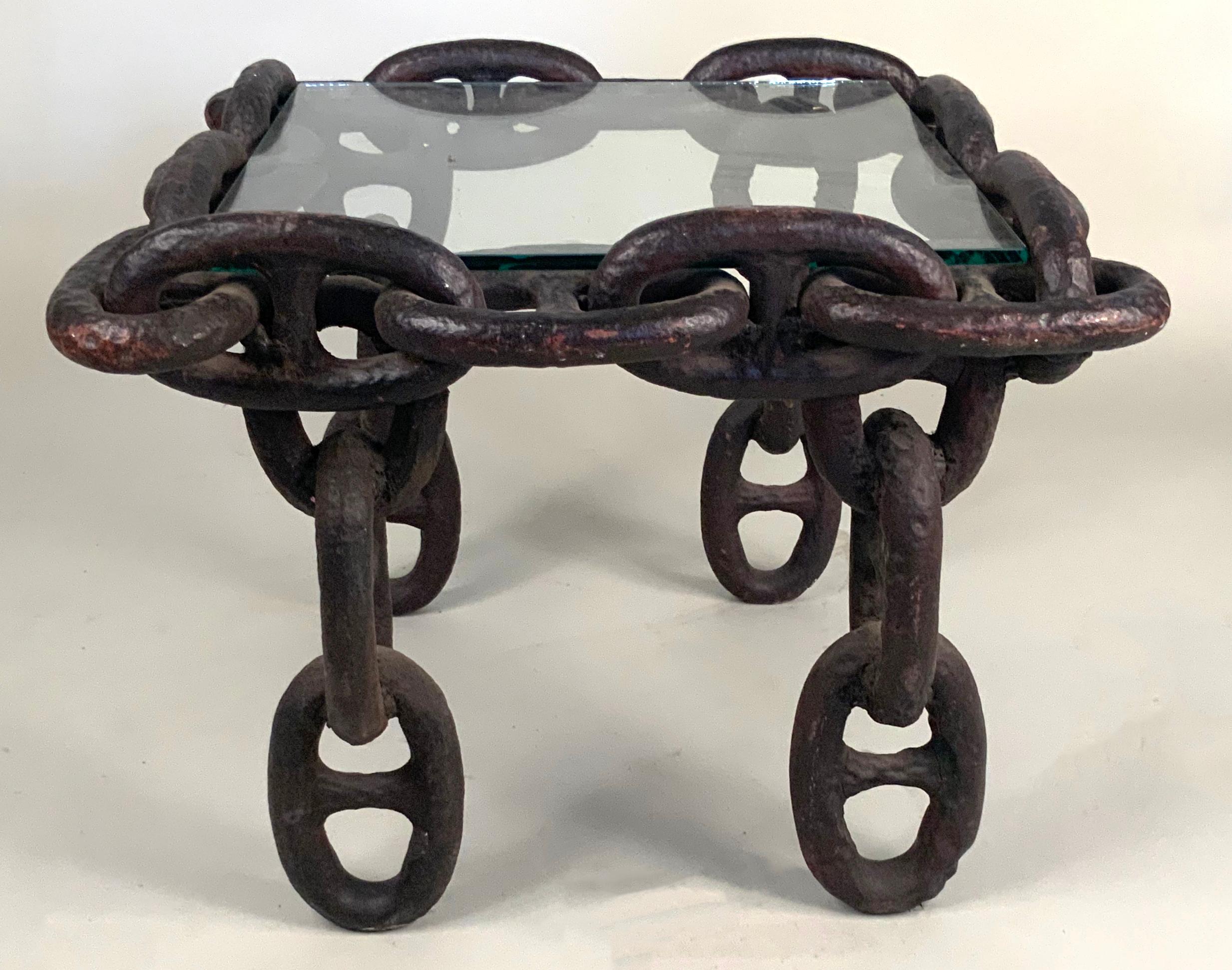 A unique antique 1940s side table or coffee table with the frame made entirely of large link in cast iron, designed to be fitted with a stone or glass top. The table currently has a glass top. Its a wonderful design in material and scale, very well