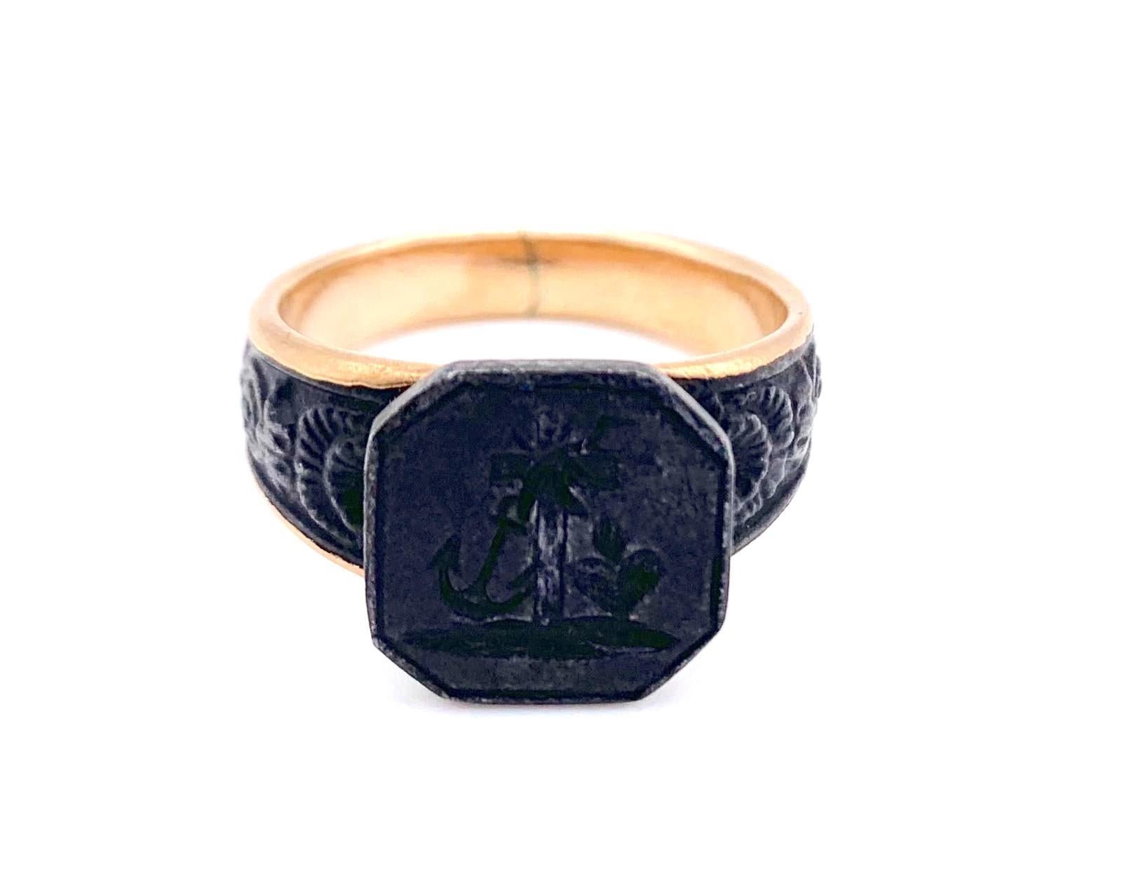Hectagonal Signet Ring 
The ring head is decorated with a cross, an anchor and a flaming heart representing faith, hope and charity. The ring shoulders are decorated with scallops and flower garlands. The iron ring has been mounted onto a 9 k gold