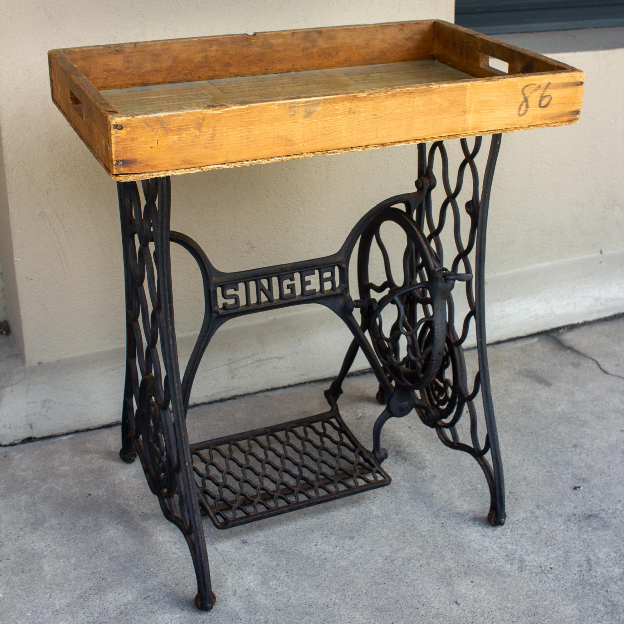 Truly a treasure from our travels, this antique iron Singer sewing machine base as been combined with a breakmaker's handcrafted wood tray then inlaid with vintage sheet music and topped with glass. The tray is removable and includes handles and