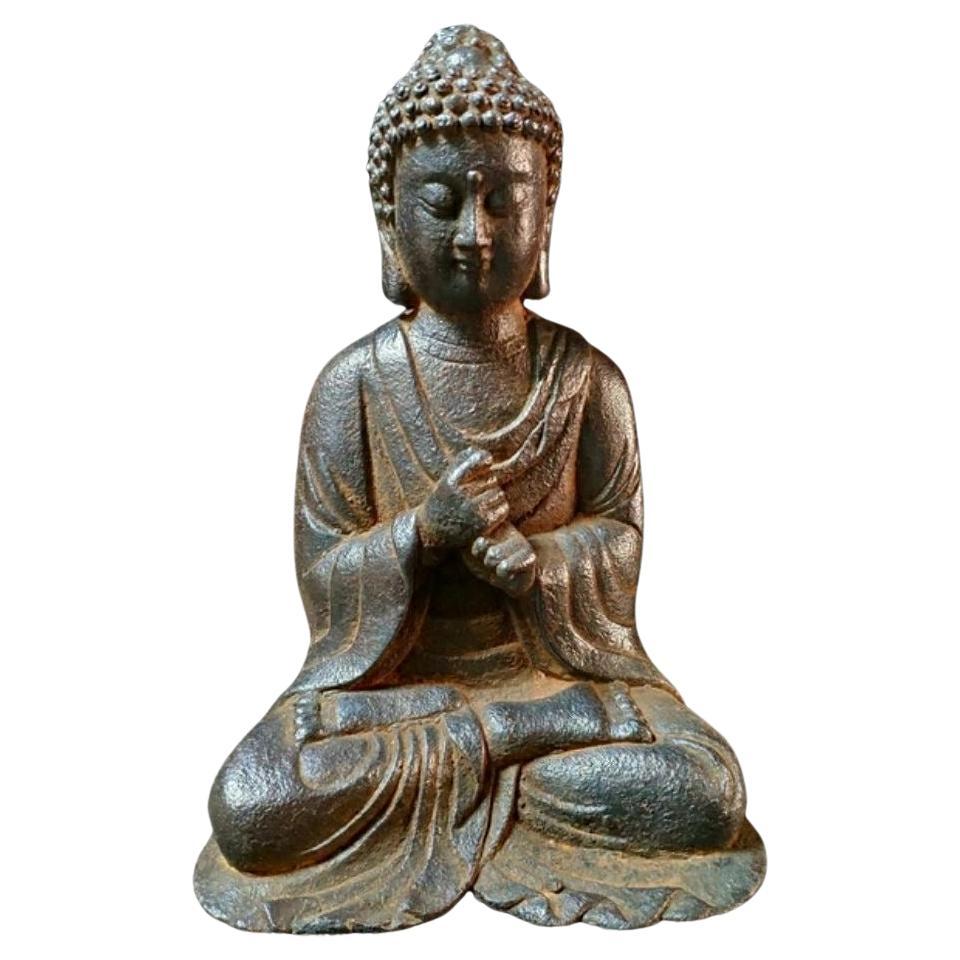 Estatua de Buda sentado de hierro viejo con los dos puños juntos