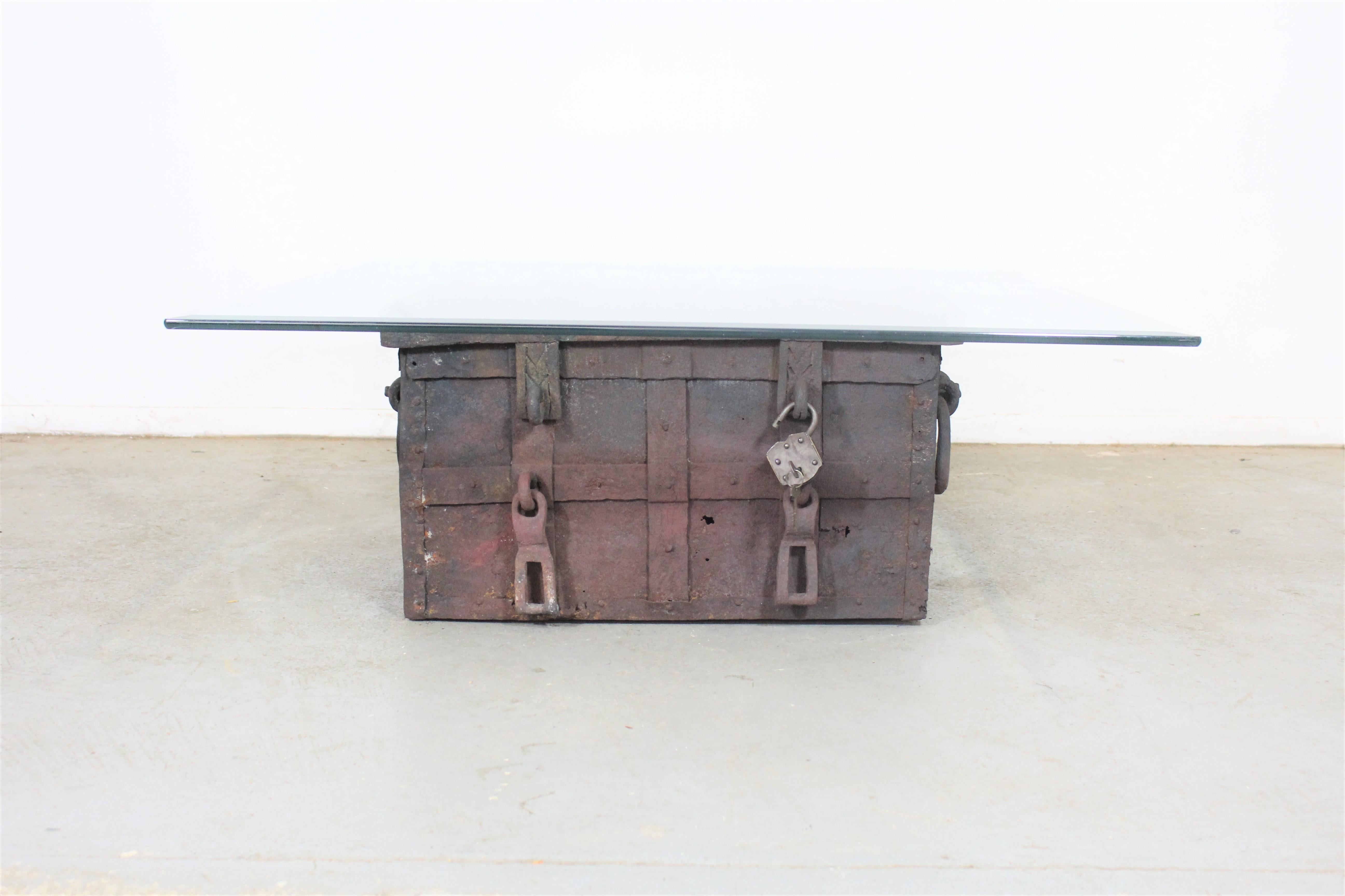 Amazing find. Here we have an antique treasure chest/iron strongbox that can double as a coffee table. Offered in this listing is the iron strongbox itself with the removable glass topping. The chest contains a till inside which is bent and has some