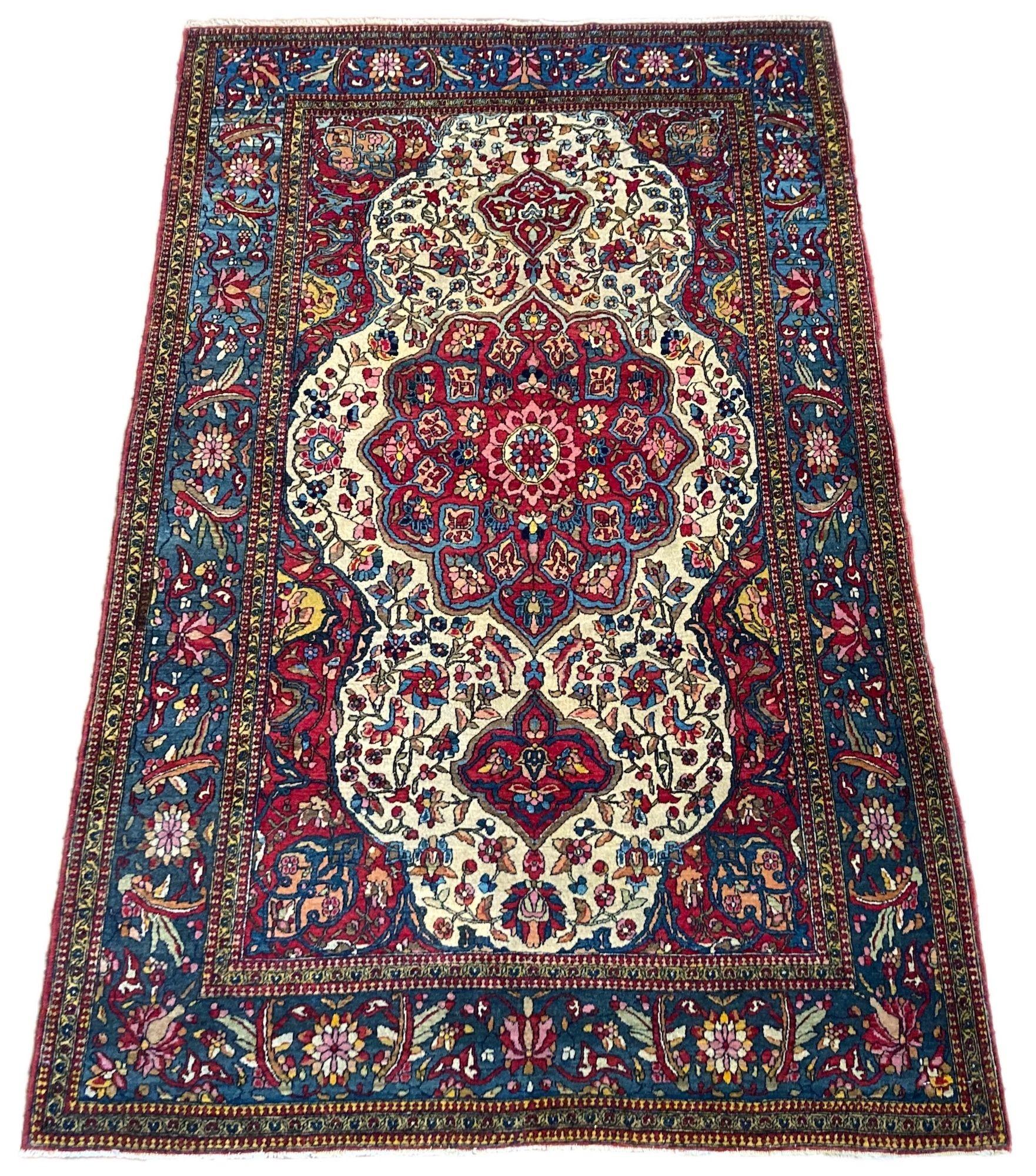 Ein hervorragender antiker Isfahan-Teppich, handgewebt um 1900 mit einem klassischen Blumenmedaillon auf einem elfenbeinfarbenen Feld und einer indigoblauen Bordüre. Fein gewebt mit großartiger Wolle und fabelhaften Sekundärfarben, insbesondere den