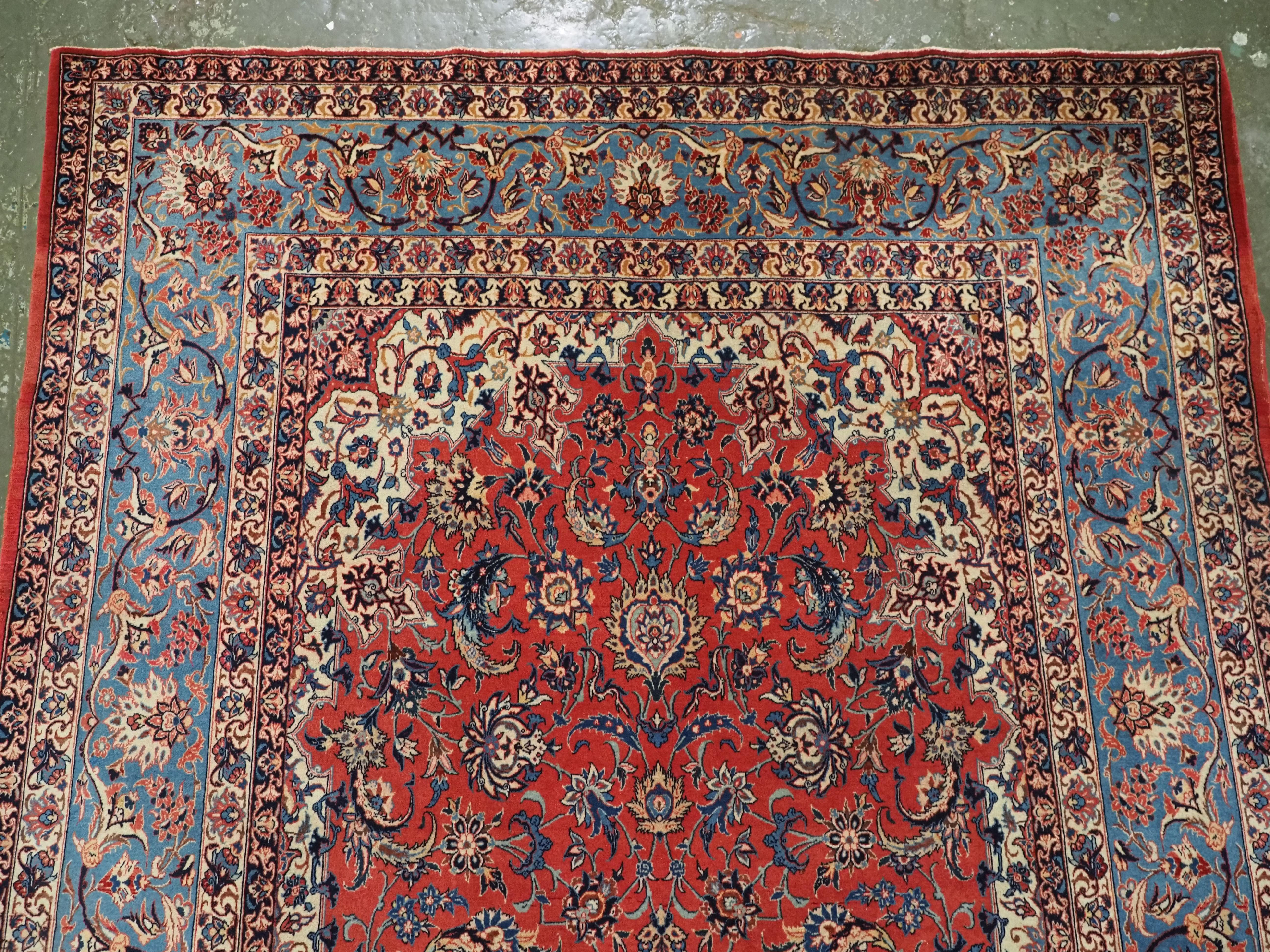 Asian Antique Isfahan rug with all over design on warm red ground, circa 1920. For Sale