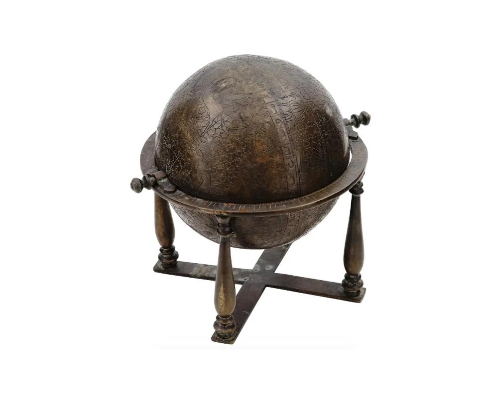 An antique Islamic brass celestial globe on a stand. The globe showcases intricate engravings and embossments that depict celestial patterns, constellations, and celestial bodies. The celestial globe serves as a representation of the Islamic world's