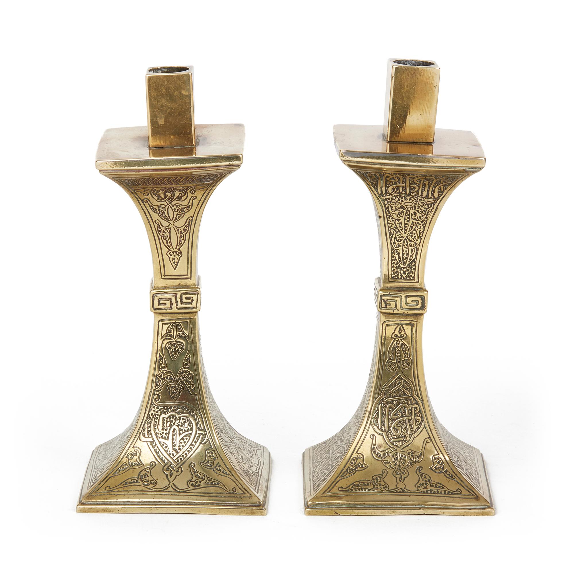 Très belle paire de chandeliers islamiques anciens, moyen-orientaux, en laiton, de forme carrée. Le corps est gravé à la main de motifs floraux et de rinceaux stylisés, décorés d'inscriptions arabes. Aucun des deux n'est marqué. On pense qu'il