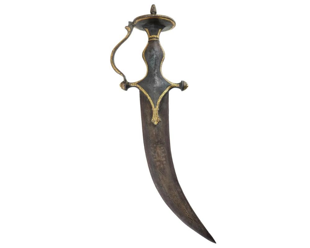 An antique Islamic curved dagger with a distinctive, bulbous hilt. This piece is intricately decorated with inlaid gold along the hilt. The hilt features a unique, bulbous pommel that resembles a vase, and has an elegant curved handle. The blade is