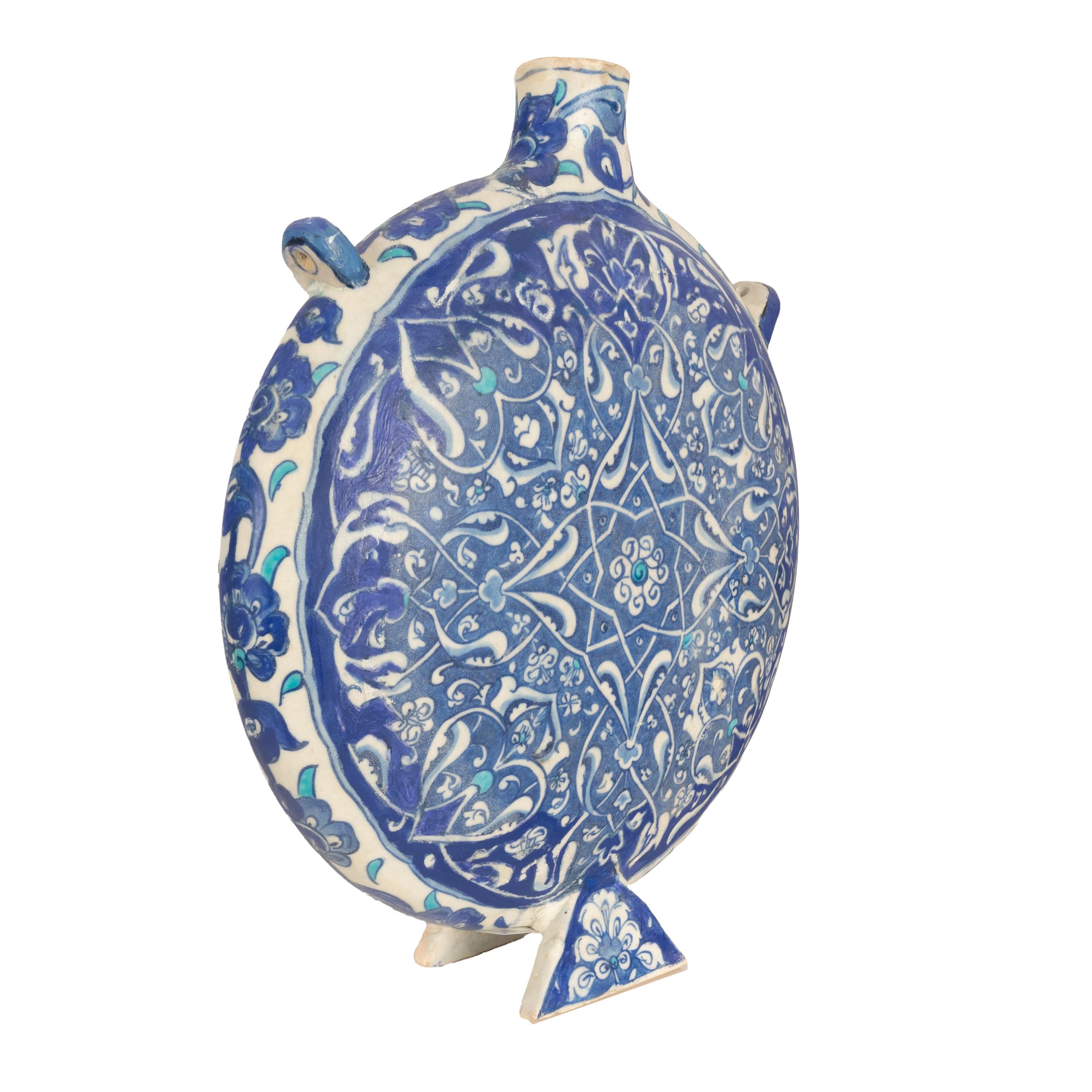 A rare & important antique Islamic Ottoman blue & white Iznik pottery pilgrim flask, Turkey or Greater Syria, circa 1600.
The flask is of circular form, around the edge of the flask is a band of floral garlanded decoration, the decoration extends to