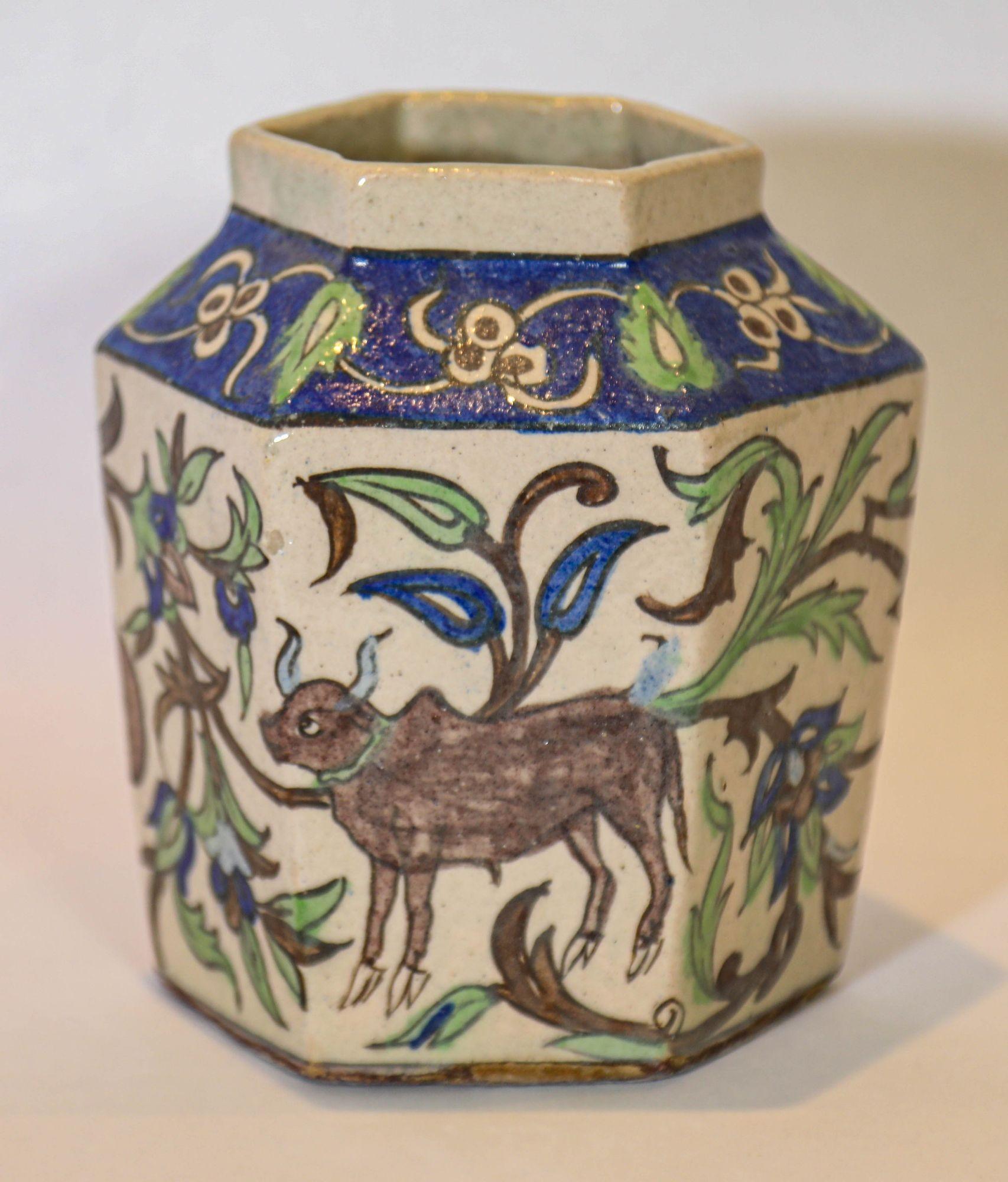 Vaso in ceramica smaltata della dinastia persiana Qajar.
Antico vaso esagonale in ceramica smaltata policroma della dinastia persiana Qajar, risalente agli inizi del 1900 o prima.
Il dipinto a mano raffigura una scena all'aperto con animali