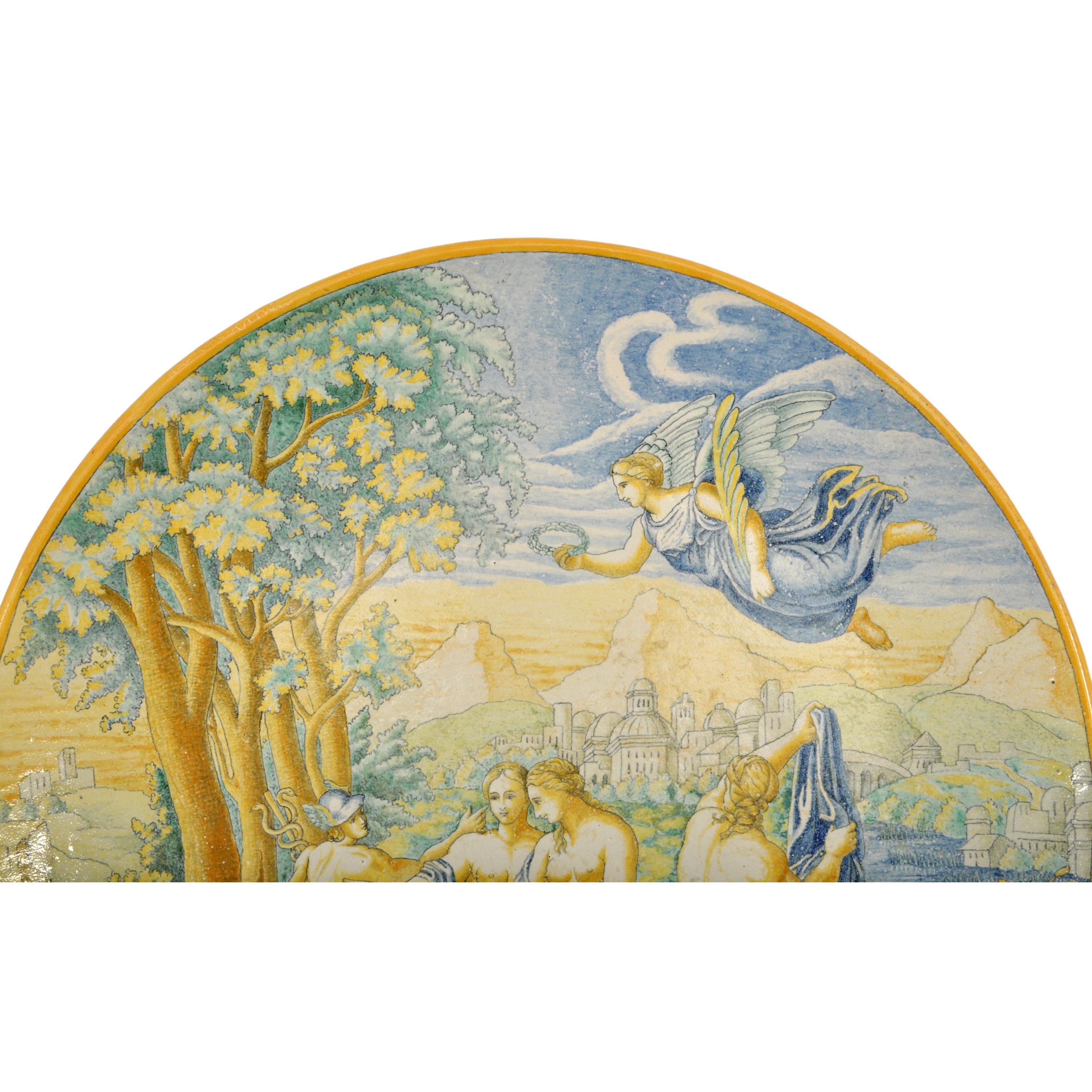 Un grand et beau chargeur italien antique en maiolica Istoriato, Urbino, vers 1800.
Ce très beau chargeur est peint à la main de figures nues néoclassiques, avec un paysage urbain à l'arrière-plan et un ange ailé au-dessus. A l'arrière se trouve un