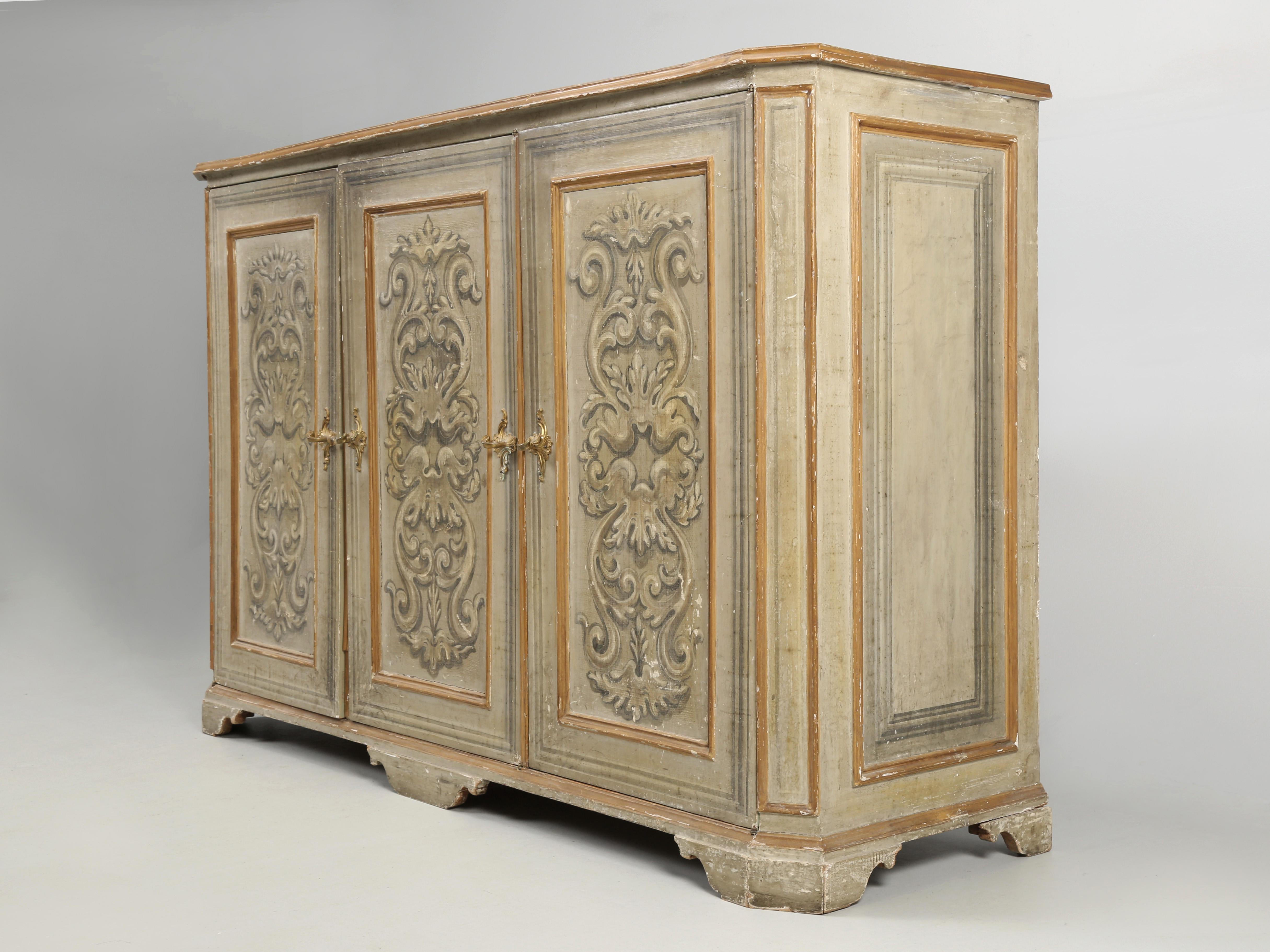 Antiguo bufé italiano de 3 puertas pintado en un estado prácticamente sin restaurar. La pintura original tiene una pátina increíble y parece haber sufrido muy pocos retoques. A juzgar por la parte trasera del bufé italiano antiguo, parece haber sido