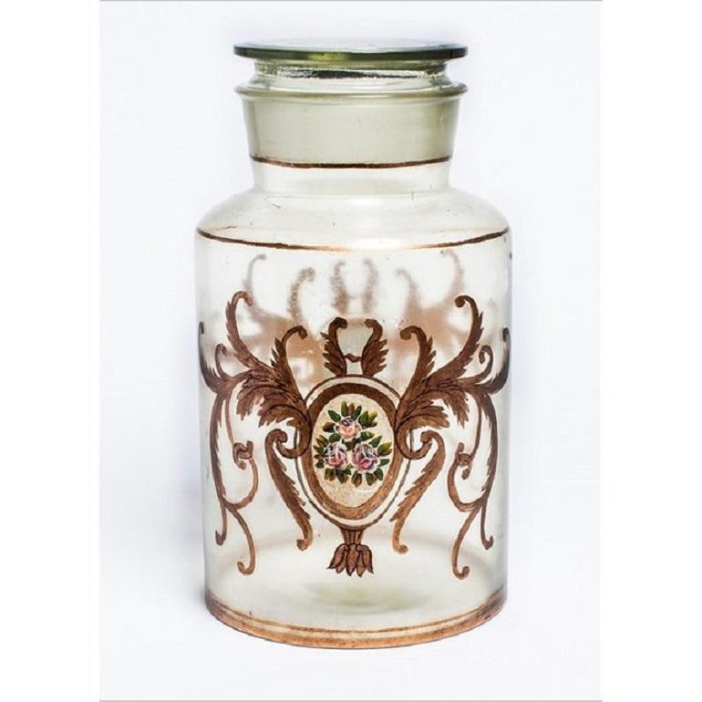 Fanciful lidded canister jar from Italy. Embellished with hand painted pink roses and gilded accents. Use this glass jar to store everyday essentials on a vanity or dressing table. Add a touch of charm and beauty to the everyday routine.