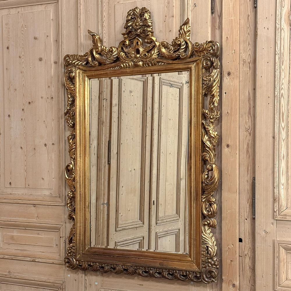 Antique Italian Baroque Carved Giltwood Wall Mirror is a timeless example of the master craftsmanship and artistry from the peninsula of Italy, renowned for millennia for such artisanry.  The entire frame is carved from solid wood, then given a