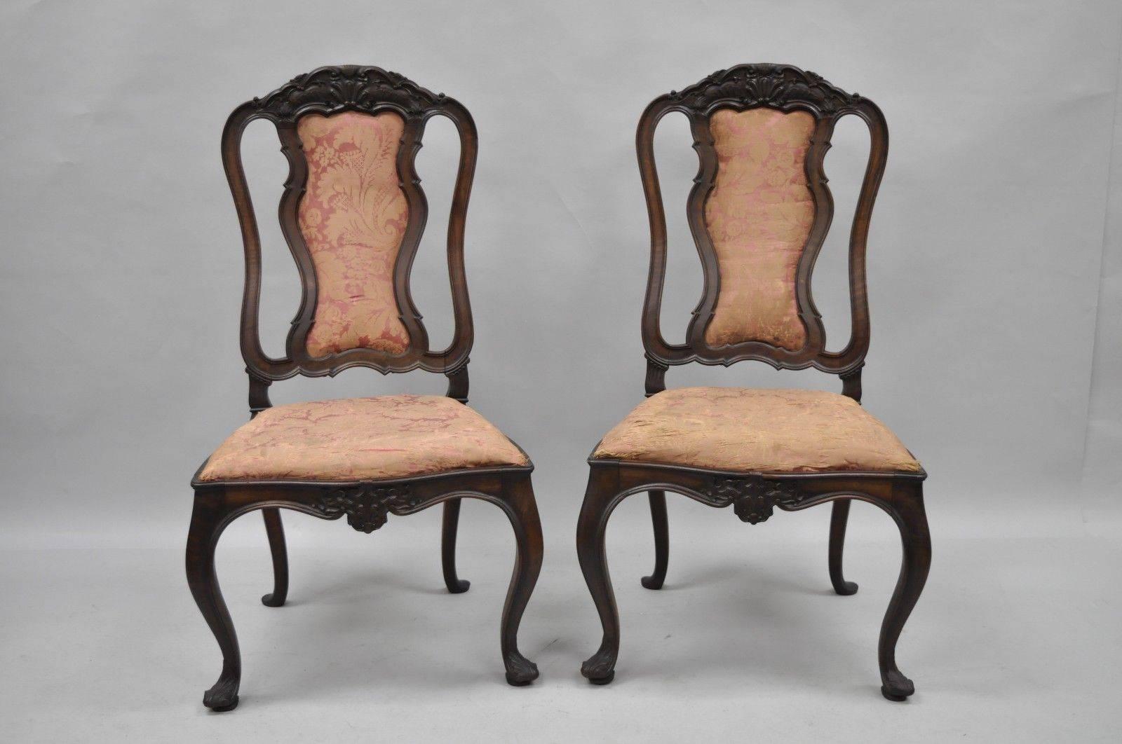 Set of six antique Italian baroque carved walnut dining chairs. Set features solid carved walnut frames, finely carved top rail and lower rail, unique wooden rear backrest, shapely upholstered backs, cabriole legs with carved feet, drop seats, and