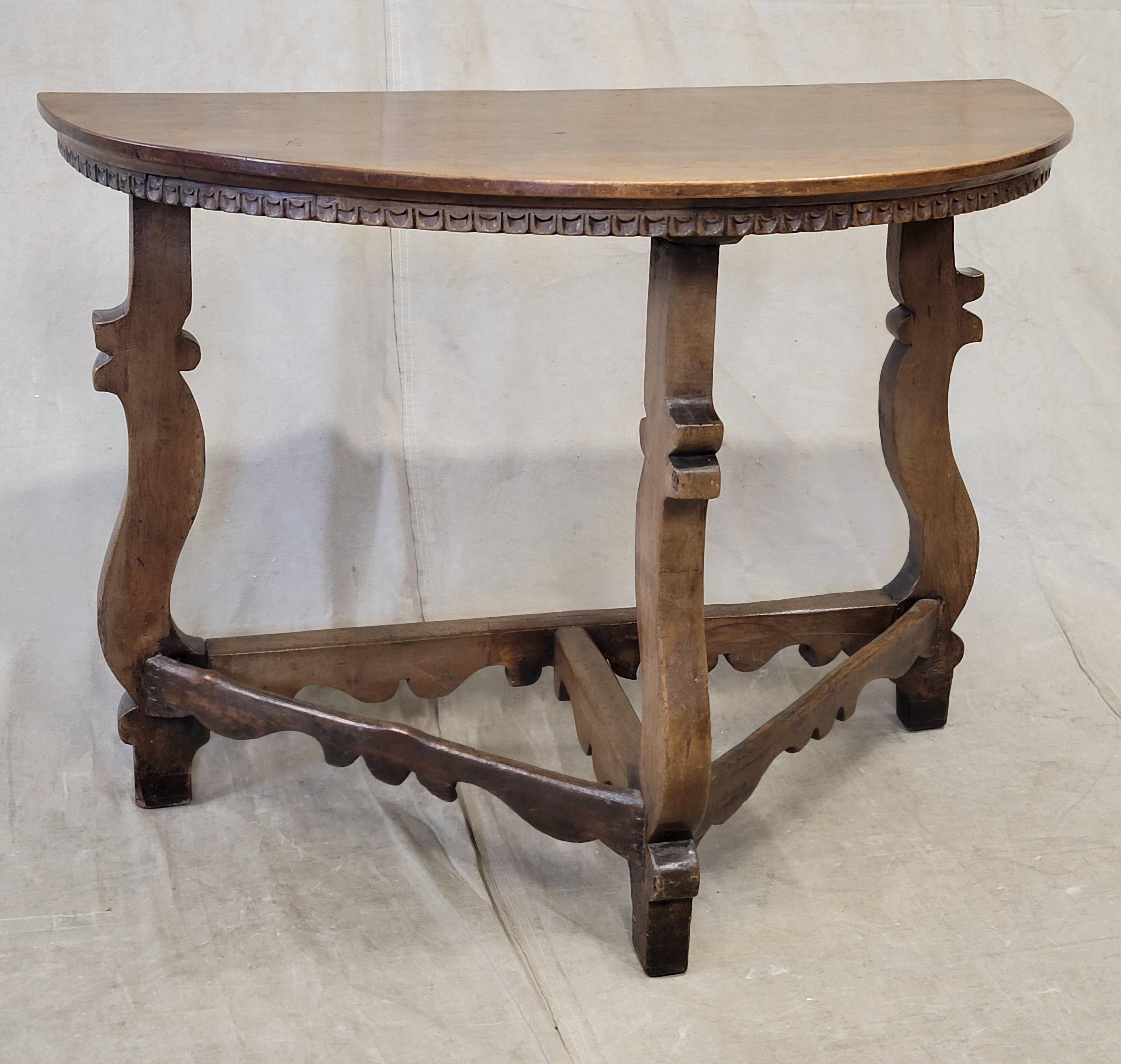 A gorgeous antique Italian baroque revival walnut demi-lune console table. Notice the carved scalloped edge on the table top and the curvilinear carved legs and stretchers. Perfect in a hall, entryway or anywhere that space is at a premium. This