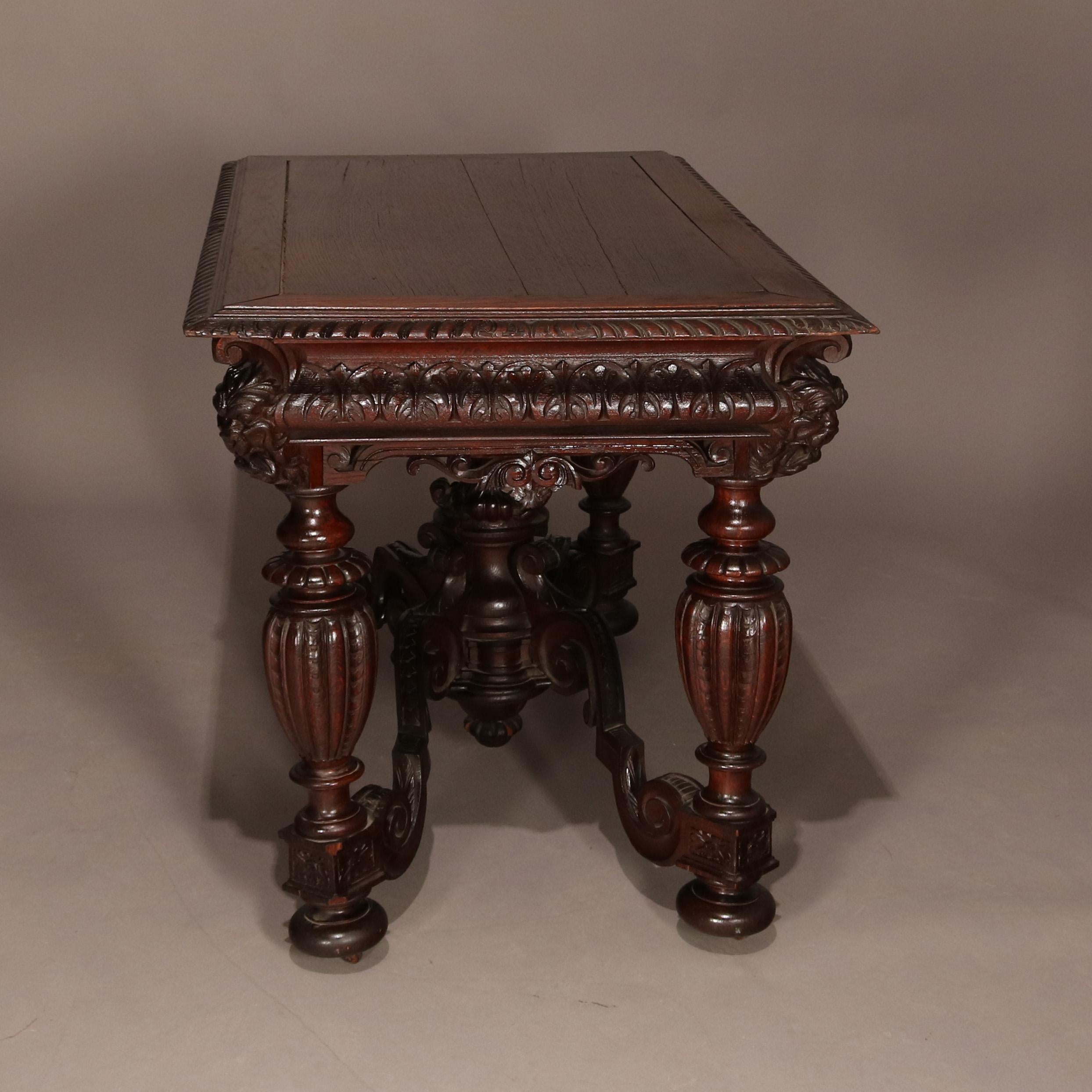 An antique Italian Baroque style figural carved mahogany library table features beveled top surmounting foliate carved apron with masks and pierced scroll form decoration and raised on heavily carved urn form legs with scroll form cross stretchers