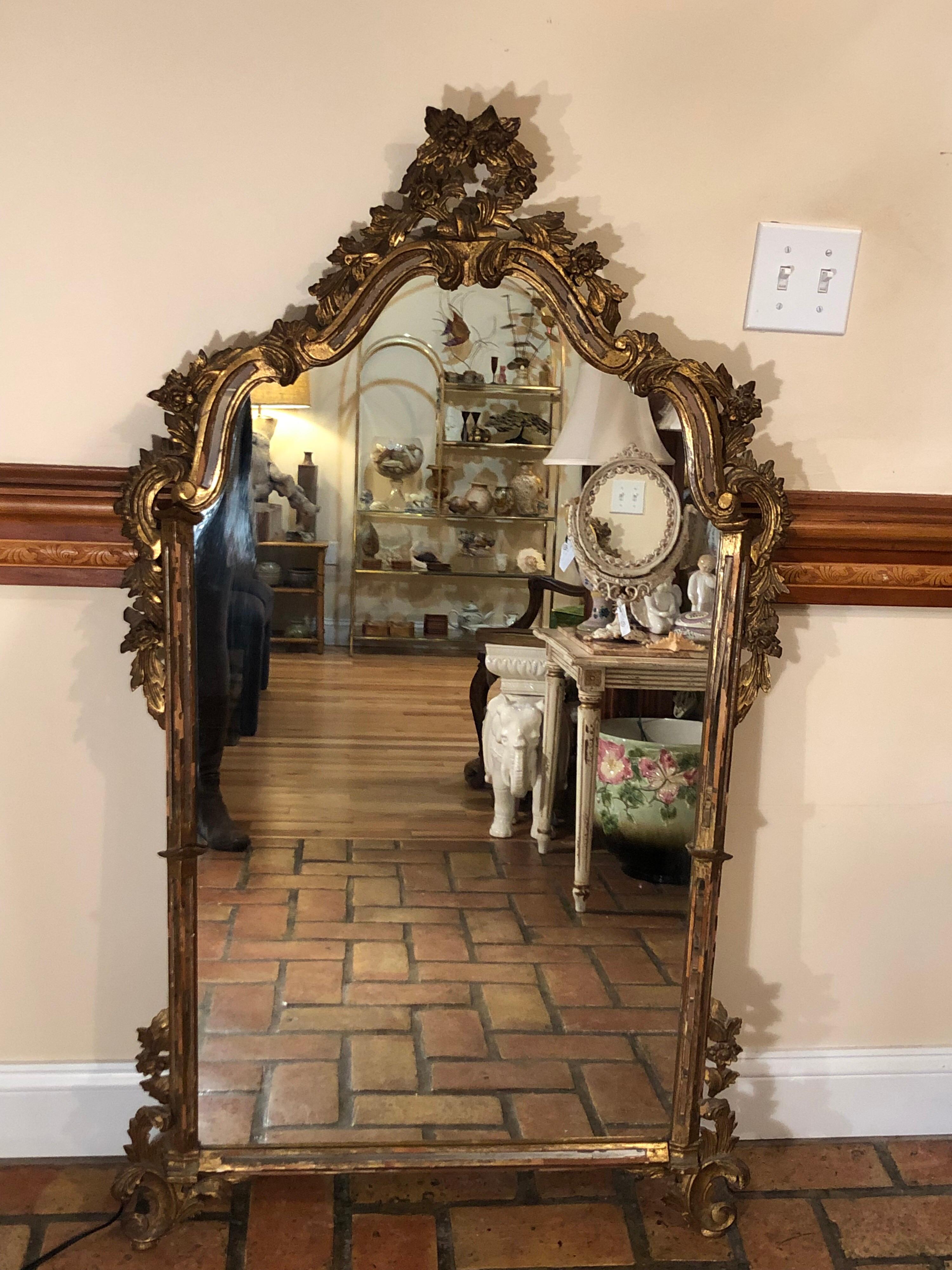 Antique Italian Baroque mirror attributed to Labarge. This aged mirror has an elegant opulence reminiscent of a Newport Mansion. It is regal in its design and brings an incredible sense of royalty to any room. Hand carved wooden mirror with mirrored