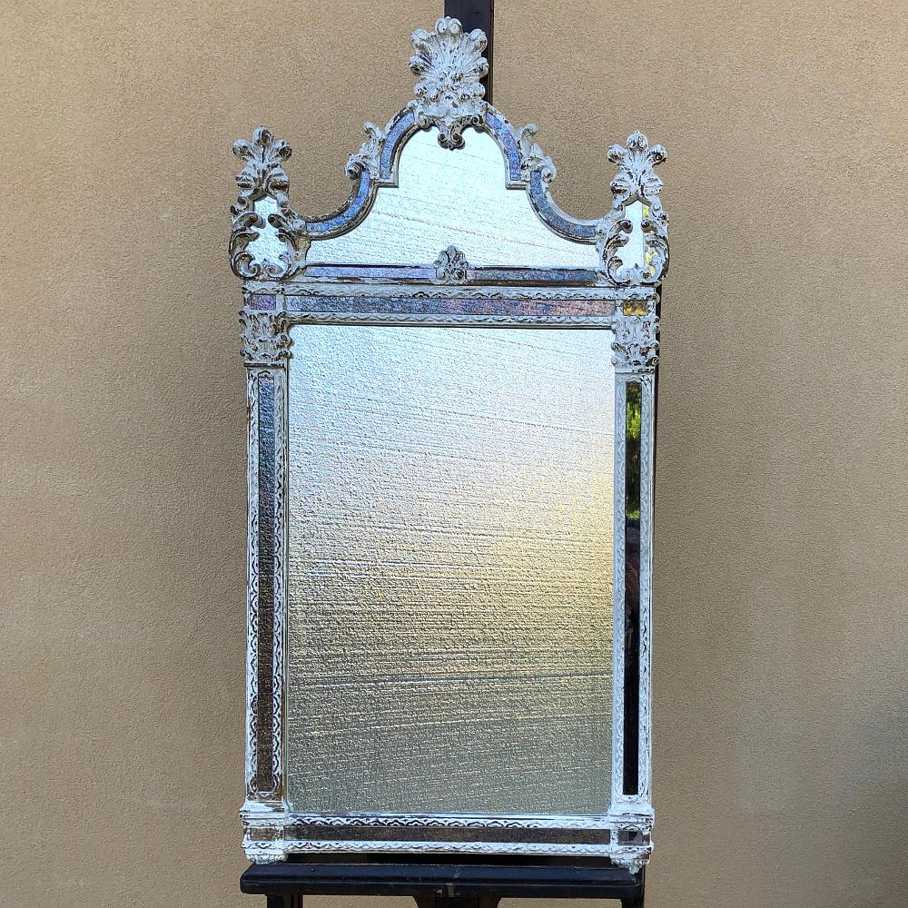 Antique Italian baroque silvered mirror hails from the storied city of Venice, and features a comparatively restrained expression of the style, with mirrored panels on the framework and crown accentuated by the flourishes of shell and acanthus leaf