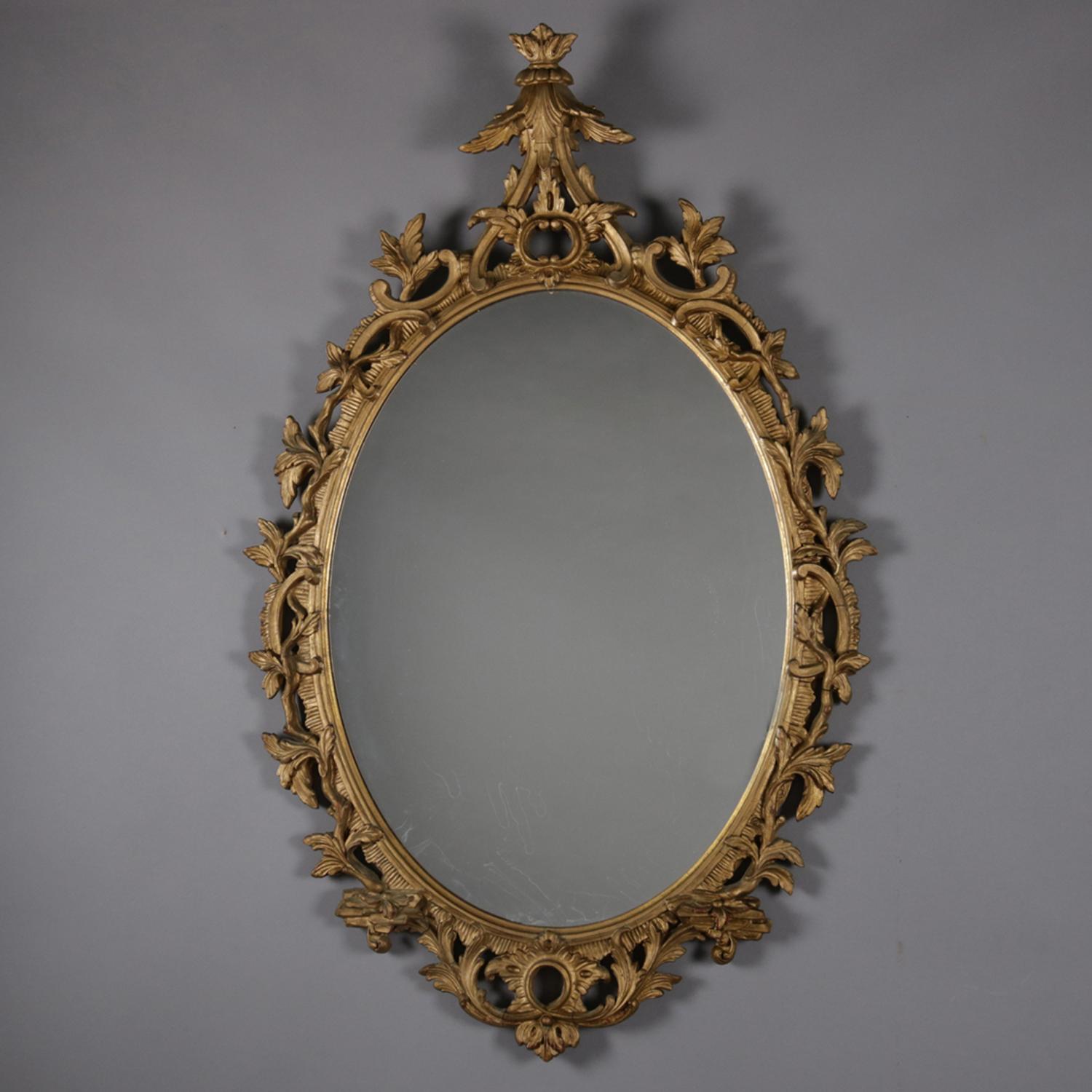 Antique Italian Baroque carved wall mirror features pierced foliate giltwood surround with fleur de lis crest, 19th century.

Measures - 48