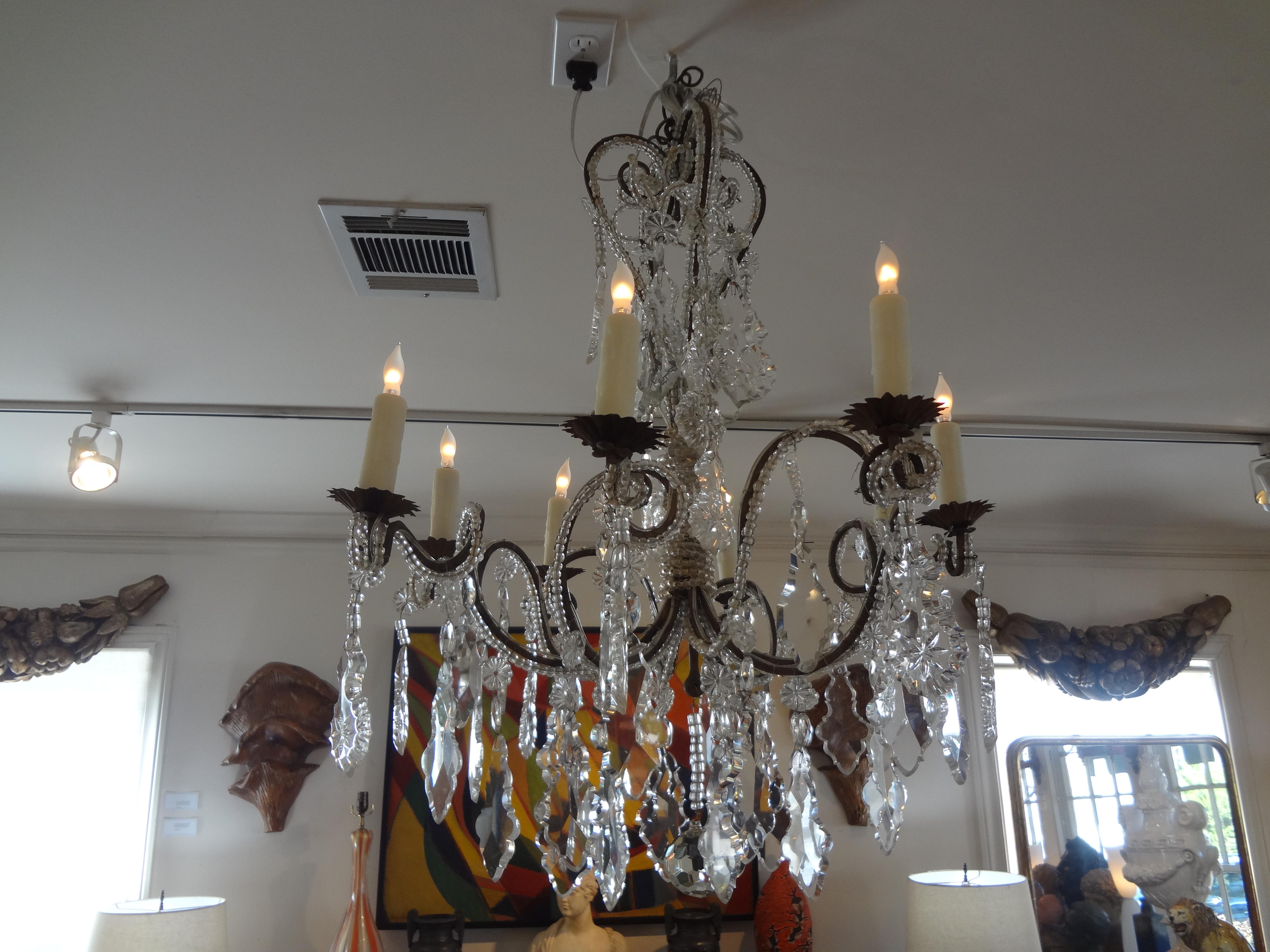 Stunning antique Italian beaded and crystal chandelier from the 1920s. This unusual Italian crystal chandelier has a crown at the top and an interesting swirl design to the beaded portion. Our antique Italian crystal chandelier has been newly wired