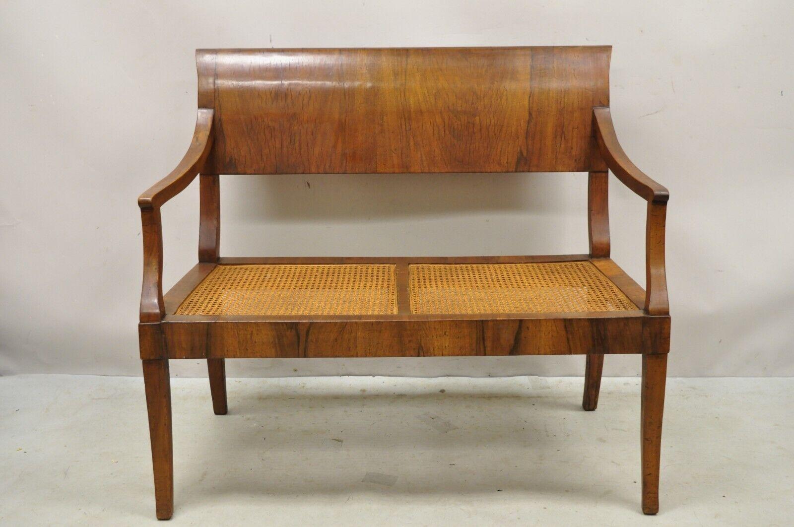 Antique Italian Biedermeier Style Elm Wood Cane Seat Walnut Bench Settee.  Item features a cane seat, beautiful wood grain, shapely saber legs. Circa  Early to Mid 20th Century. Measurements: 36
