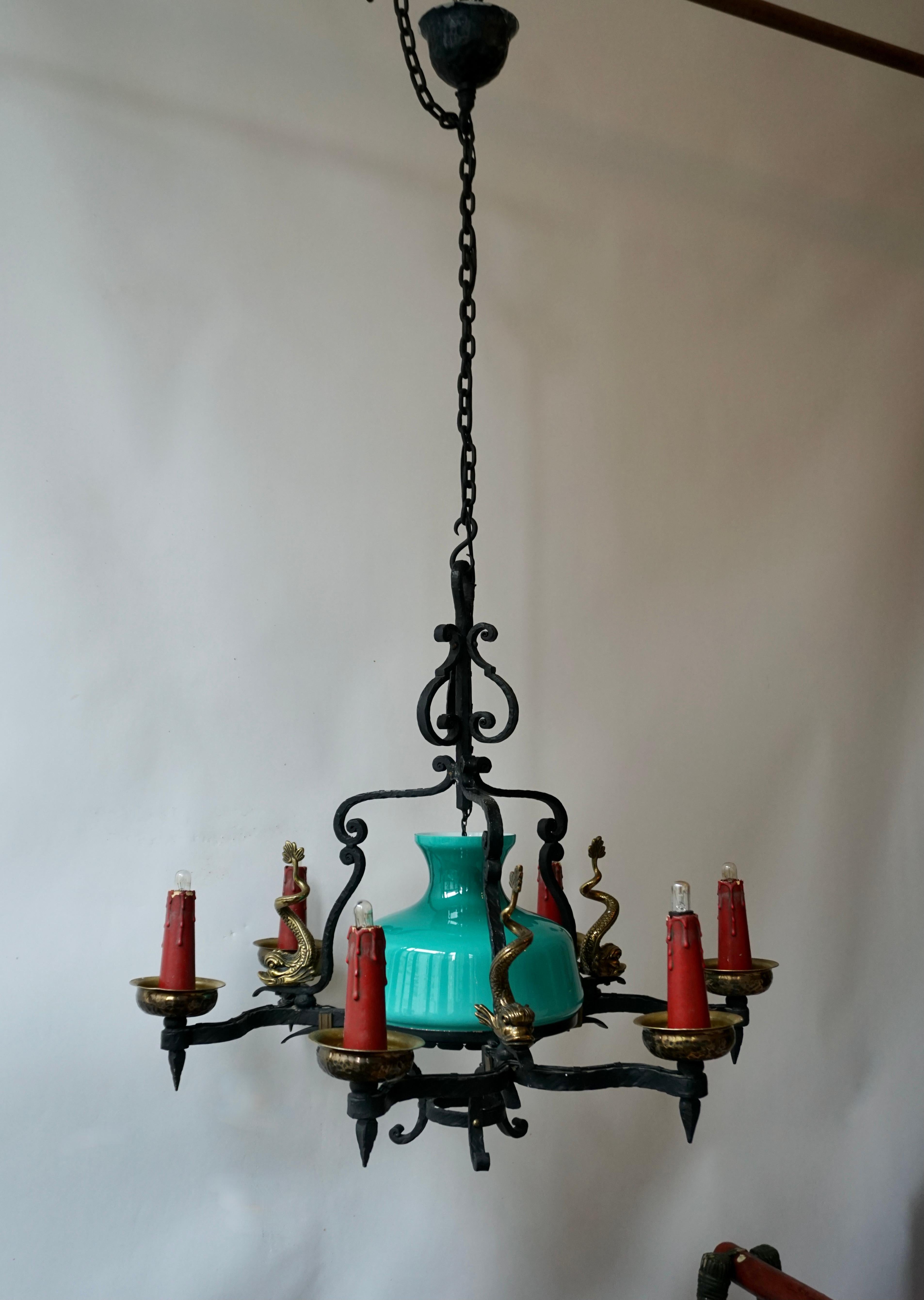 1950s very ornate chandelier with original green Italian Murano glass and bronze ancient classical dolphin.
 
This unique antique Italian wrought iron chandelier has an organic feel with its six scrolled arms and three beautiful bronze fish