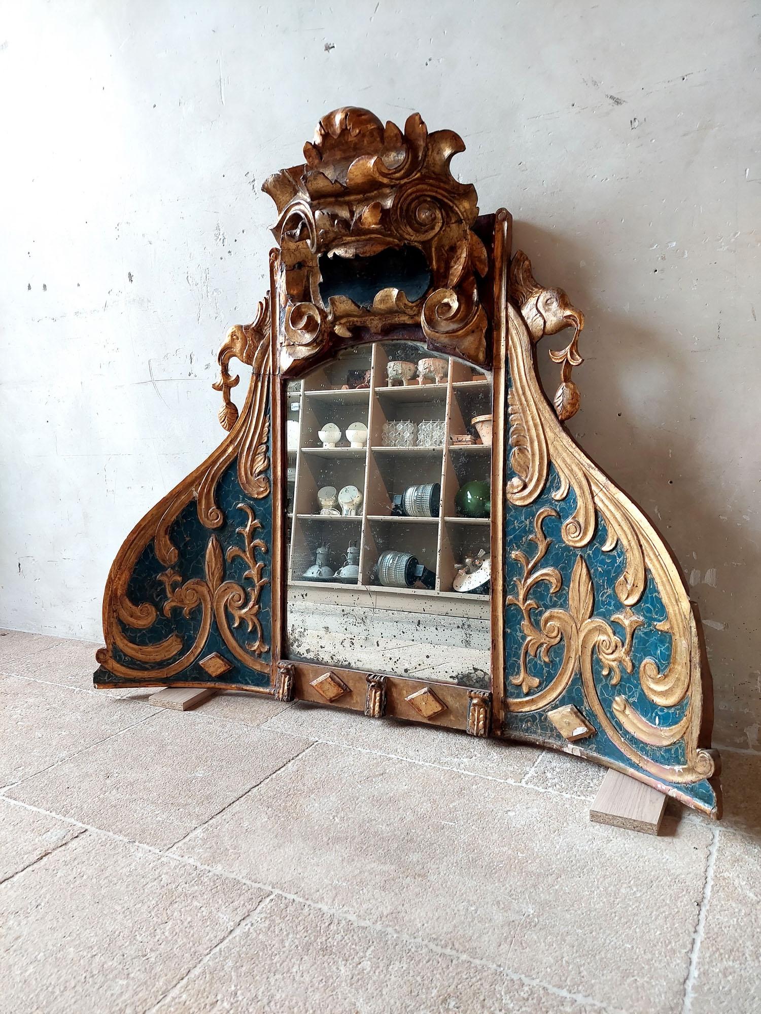This unique and special mirror is made from an Italian 18th century church niche. The wood-carved frame has a slightly concave shape, and has graceful decorations such as C-shaped curls, diamond shapes, leaves and birds in a beautiful crackle blue