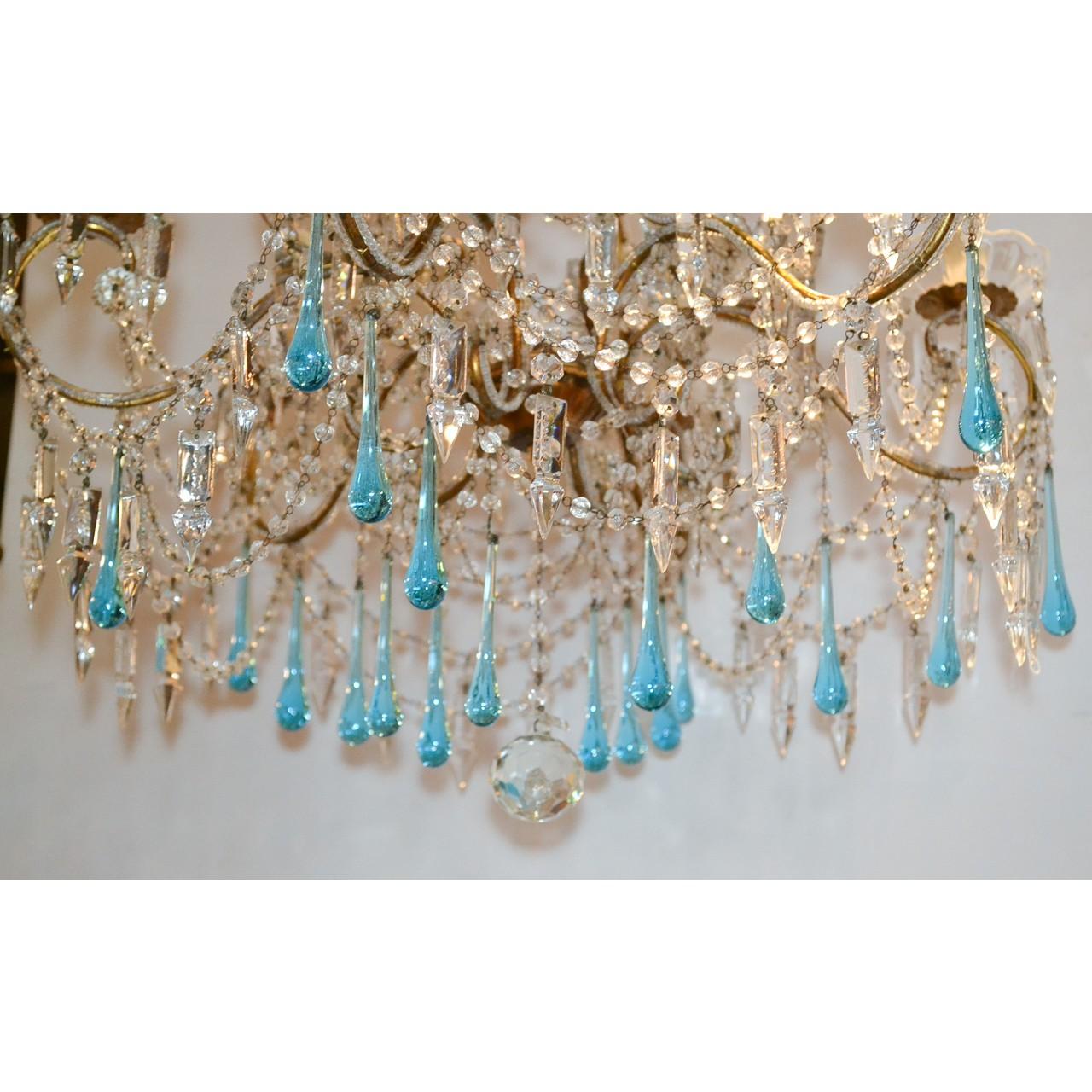 Exquisite early 20th century Italian crystal chandelier with multiple cascading strands of faceted crystal beads. Adorned overall with spear-shaped crystal prisms and beautifully accented with sky-blue crystal teardrops. The scrolled arms mounted