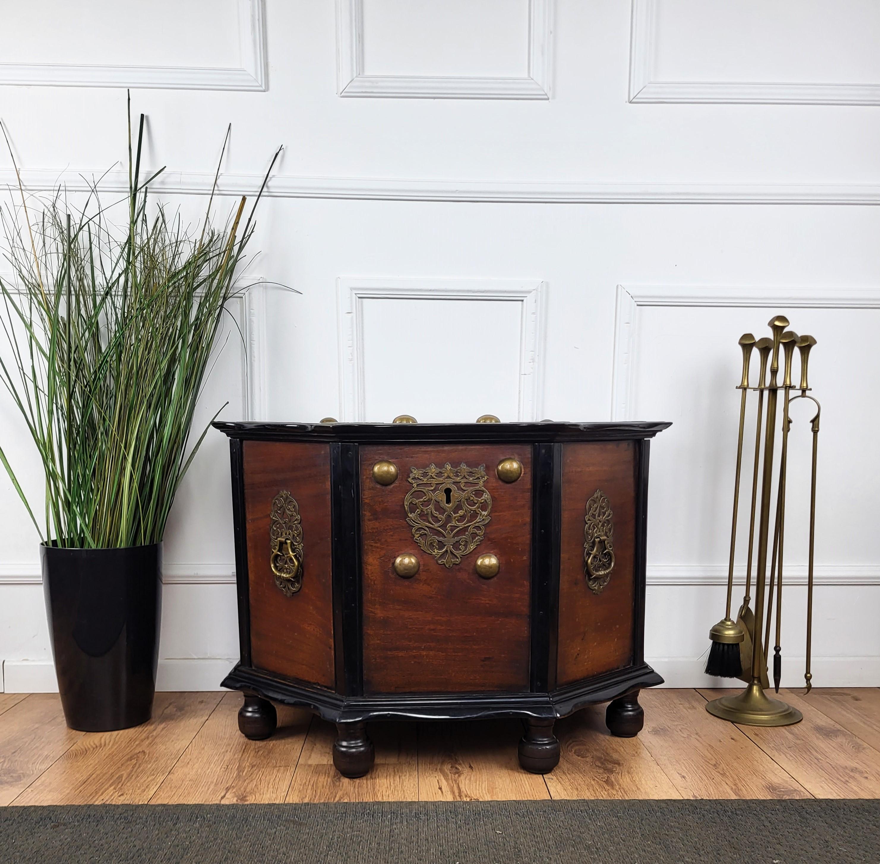 Beautiful Italian antique chest, trunk in great solid wood with blackened carved edges and frames, great original brass handles, escutcheons and decors on all sides, completed with the bun feet. This very decorative piece can be used in any room for