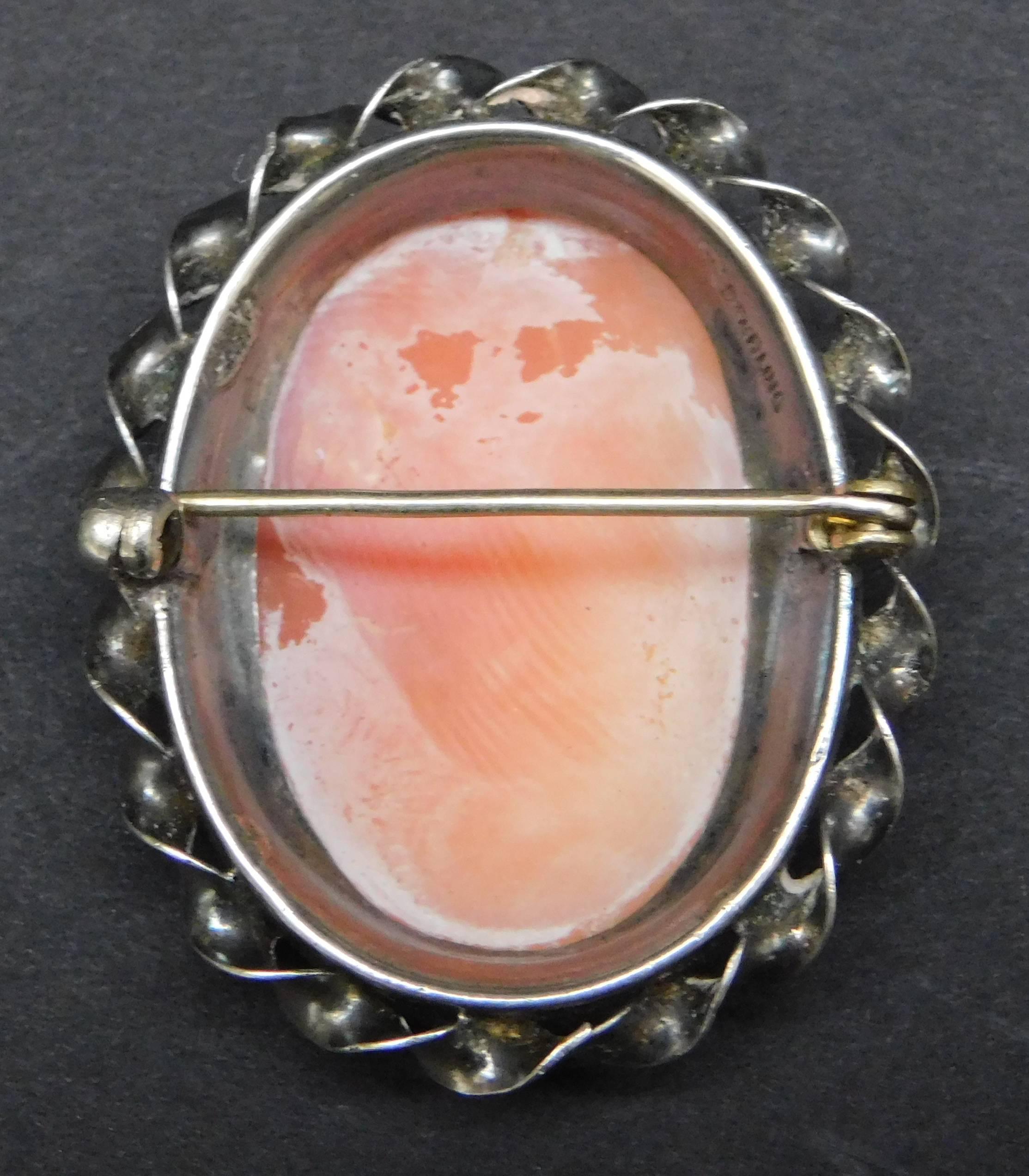 A lovely victorian Cameo brooch of hand carved conch shell set into sterling silver with a hand twisted silver frame. The medium size makes this the perfect brooch for a young lady.