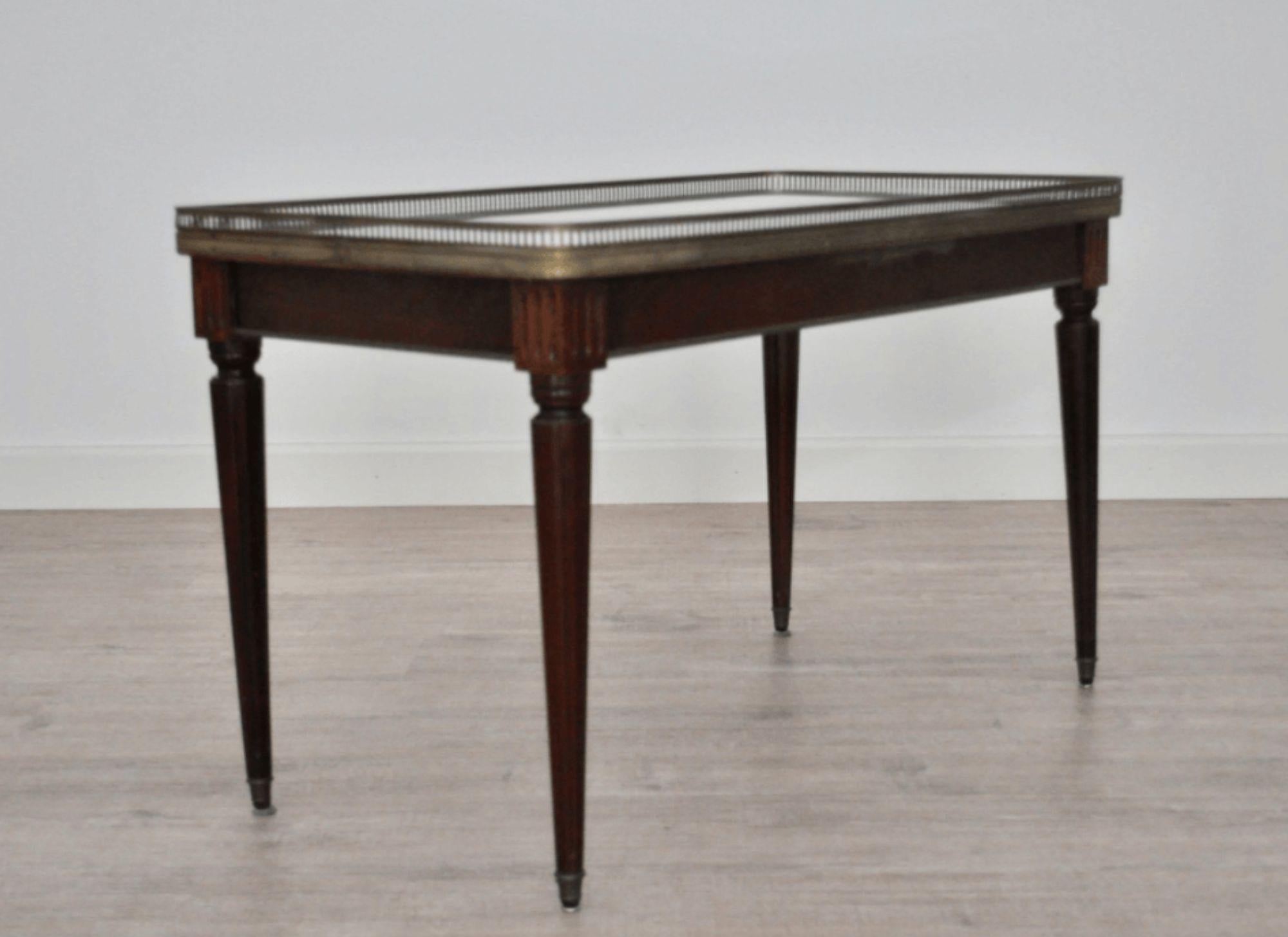 Bringen Sie einen Hauch von zeitloser Eleganz in Ihren Wohnbereich mit diesem beeindruckenden antiken italienischen Couchtisch. Dieser Tisch aus luxuriösem Carrara-Marmor, edlem Mahagoni und elegantem Messing ist eine perfekte Mischung aus