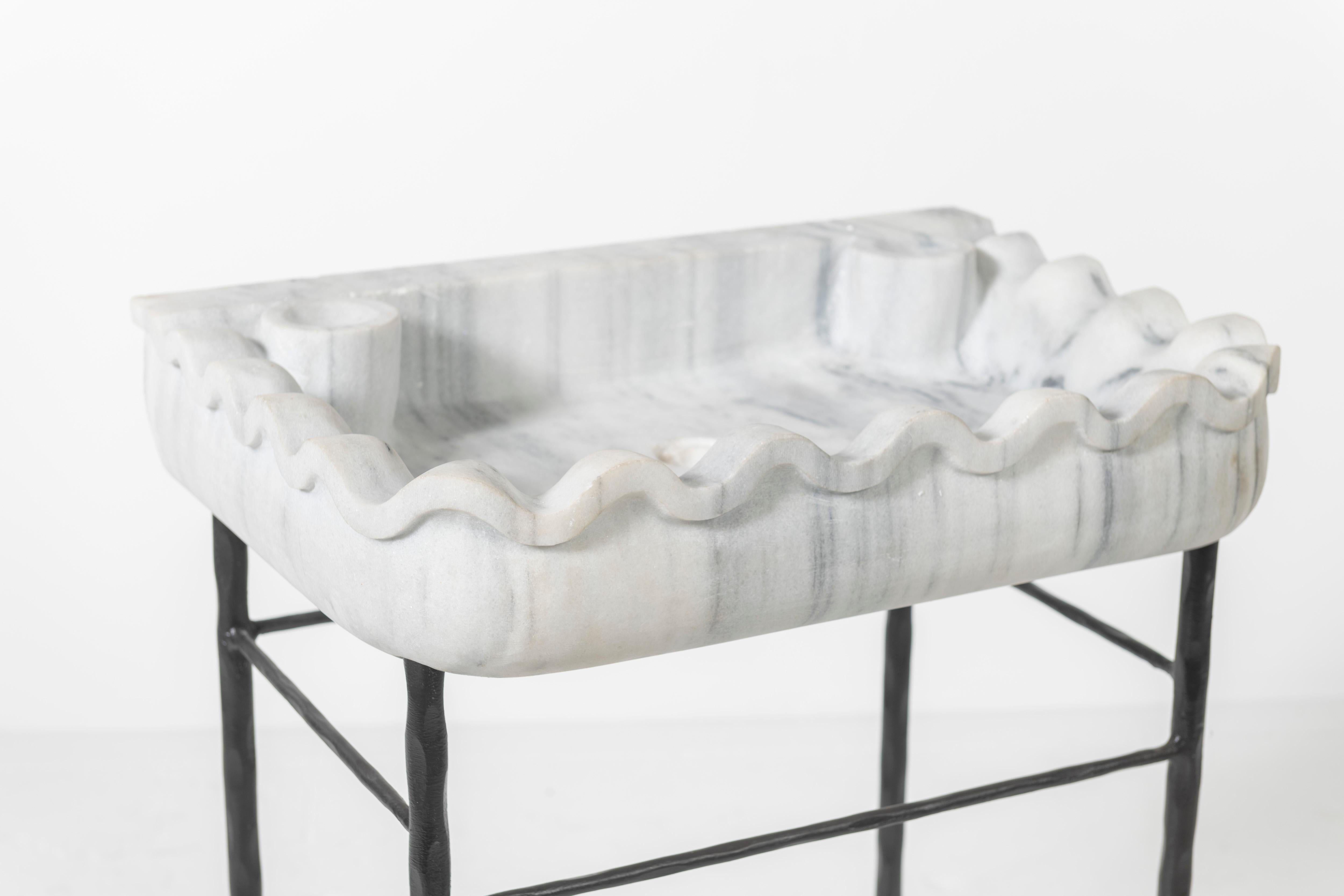 Late 19th Century Italian Carrara Marble Sink Basin, cut from one block of Carrara marble, featuring the serpentine shaped fluted surround. The basin rests on a 
forged iron stand that is also sculpted in a gentle wave. Stunning piece for either