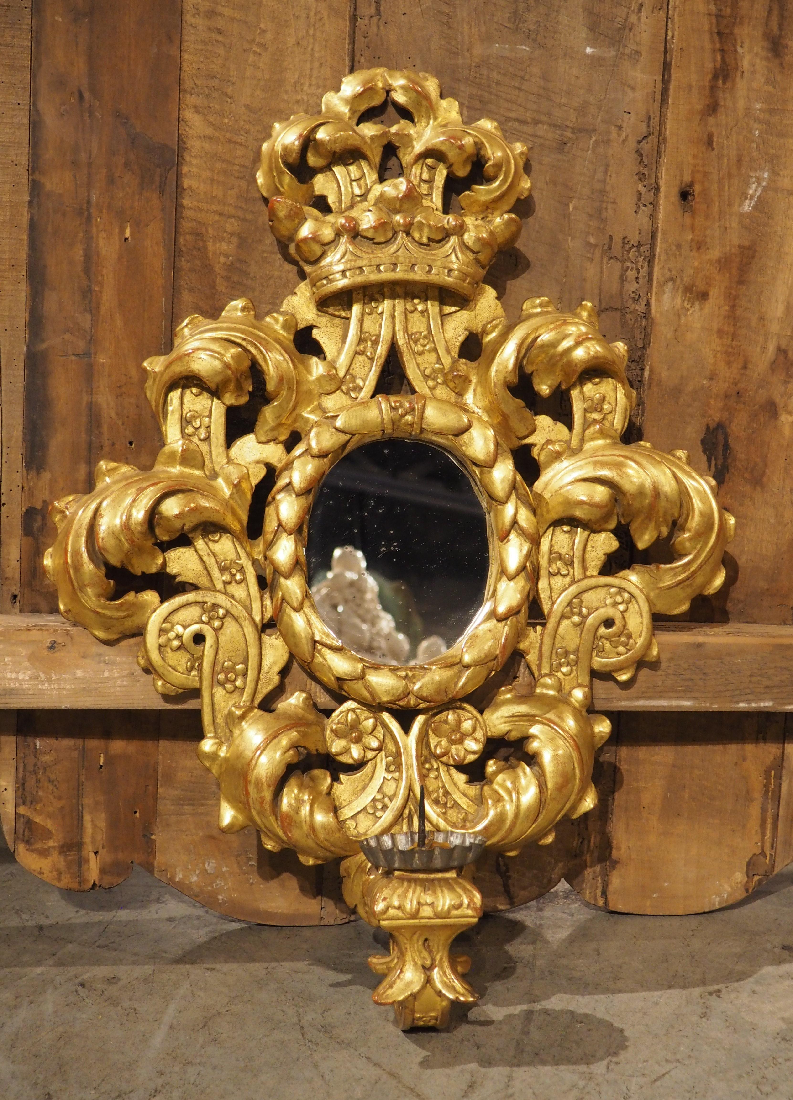 Sculpté à la main Ancienne applique murale italienne sculptée et dorée ovale miroirée, 19e siècle en vente