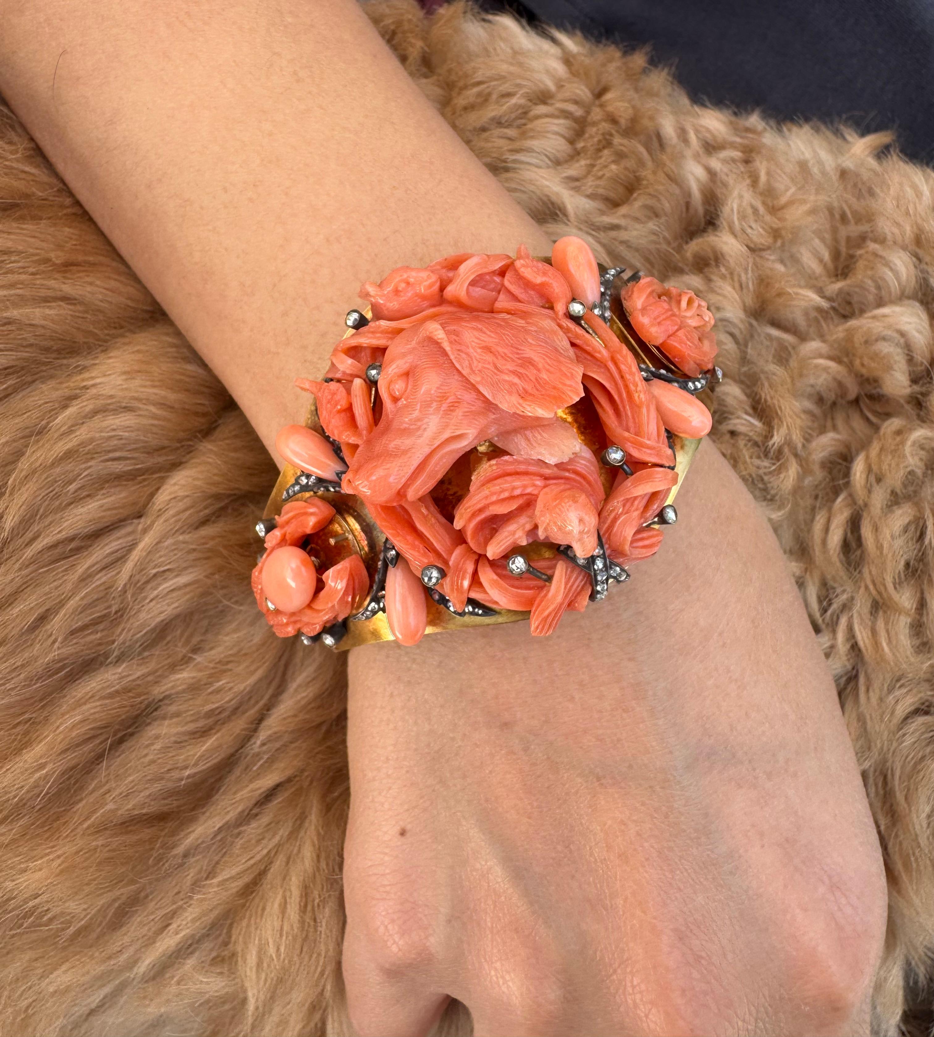 A striking 19th-century Italian bracelet showcasing masterful hand-carved Mediterranean coral in an elaborate hunting dog motif. The vivid orange-red coral is intricately sculpted into the head of a retriever surrounded by detailed floral and