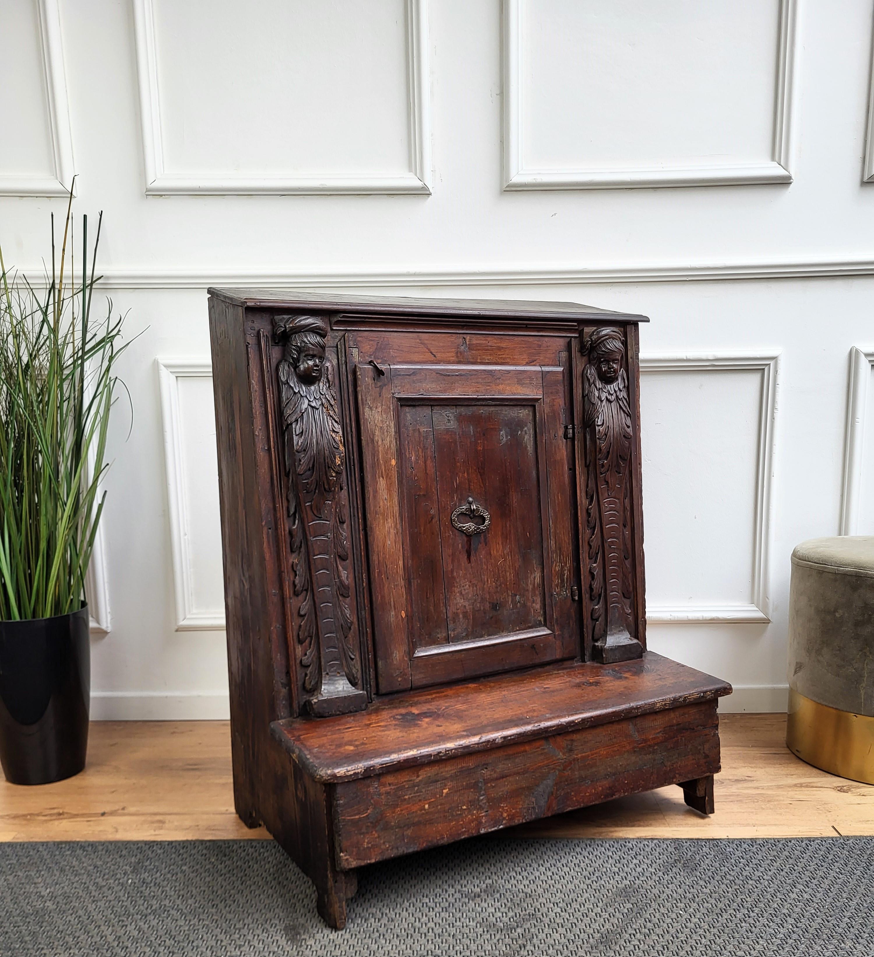 A good antique Italian Oratoire or Prie Dieu walnut cabinet crafted in beautiful wood, it stands on short legs over a knee resting platform base. The religious kneeler features two side carved columns with a central door with inside storage and the