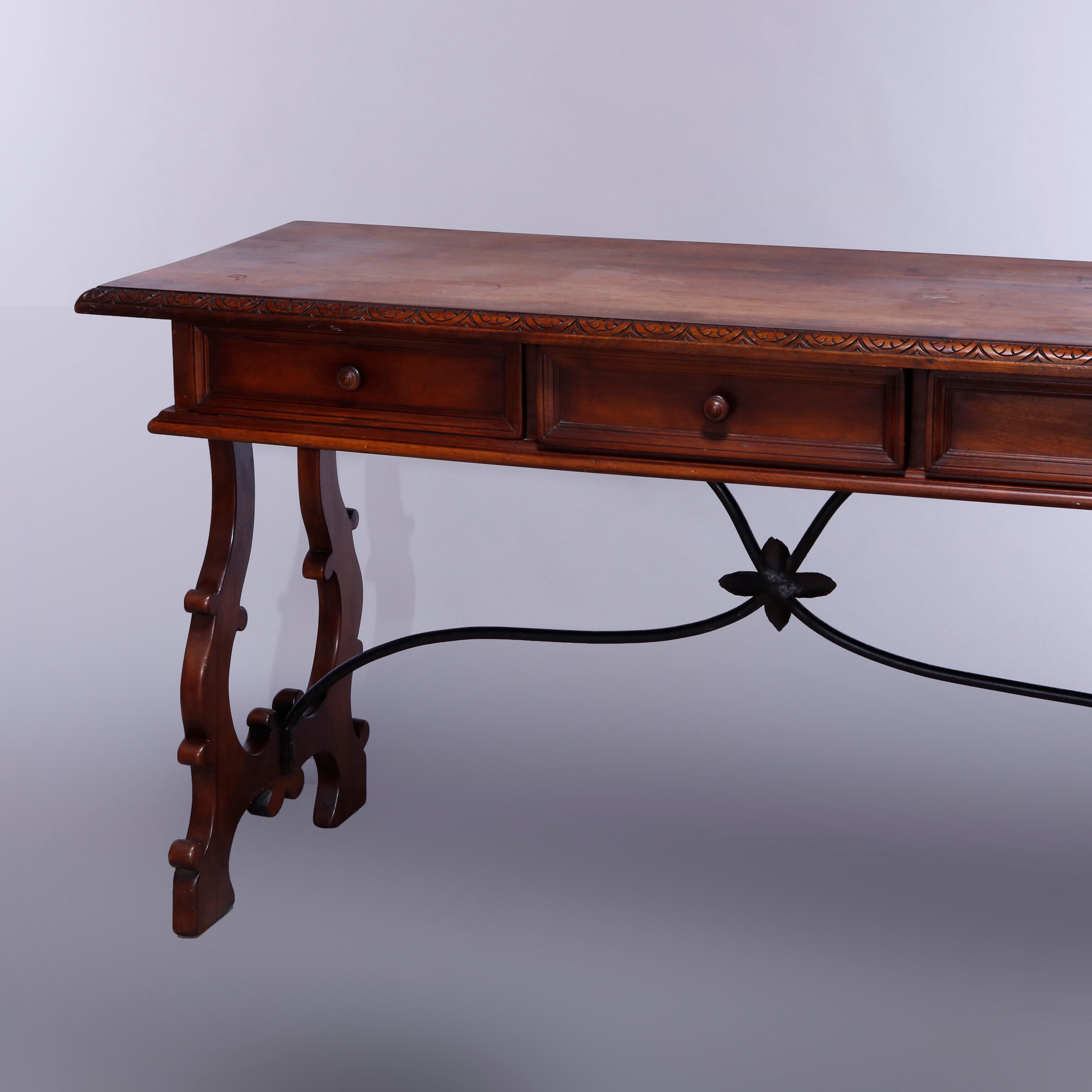 An antique Italian console or library table offers walnut construction with top having carved stylized foliate trimming over triple drawer case, raised on trestle base with shaped lyre form legs having iron stretcher, C 1910

Measures: 32.25