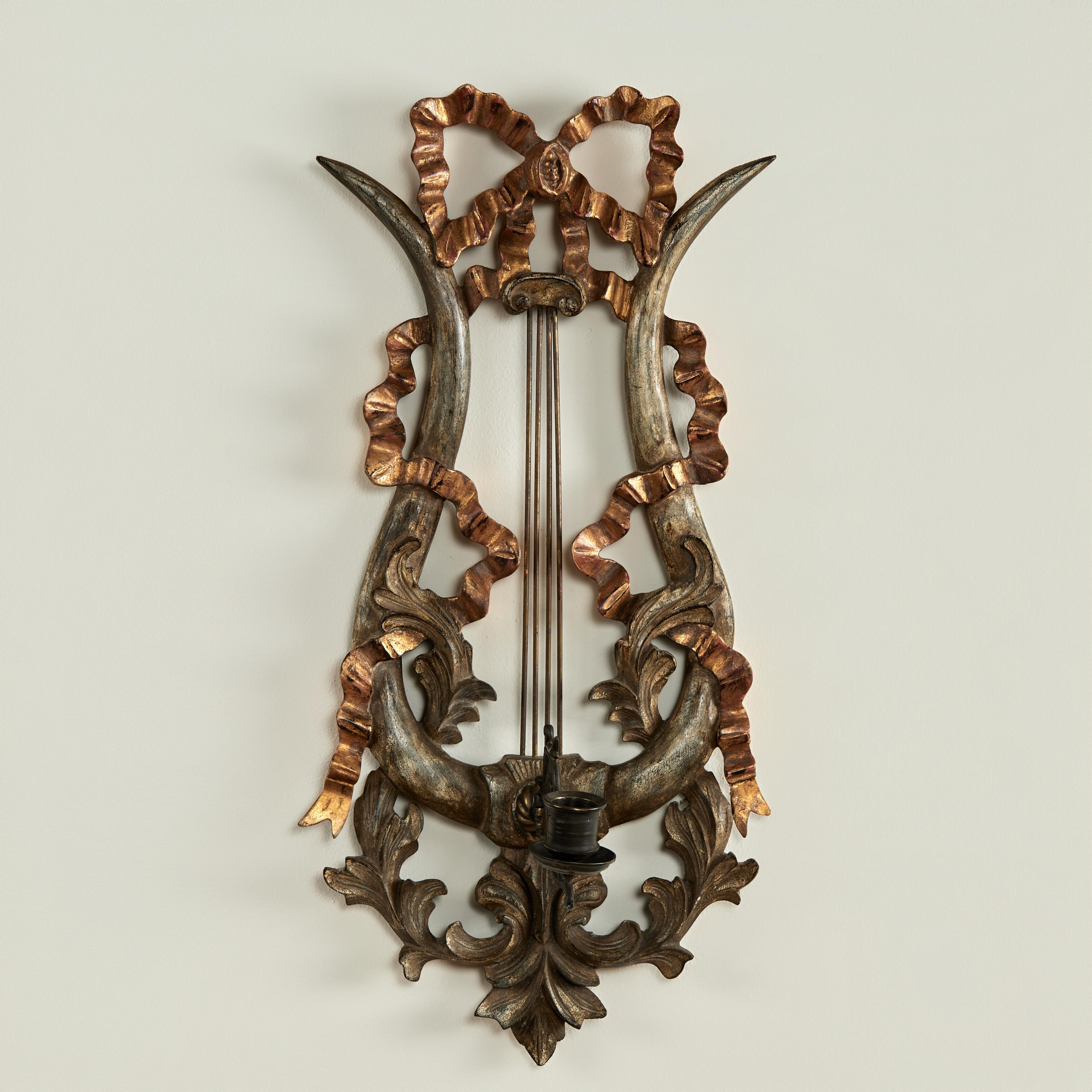 Paire d'appliques murales italiennes antiques néoclassiques avec un flair musical, fabriquées en bois sculpté dans un motif de lyre avec des cordes en métal ayant des rubans sculptés et dorés et des feuilles d'acanthe argentées tenant une coupelle